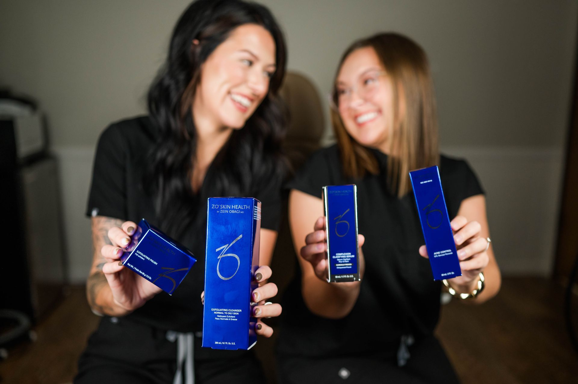 A woman is smiling with her hands on her face.