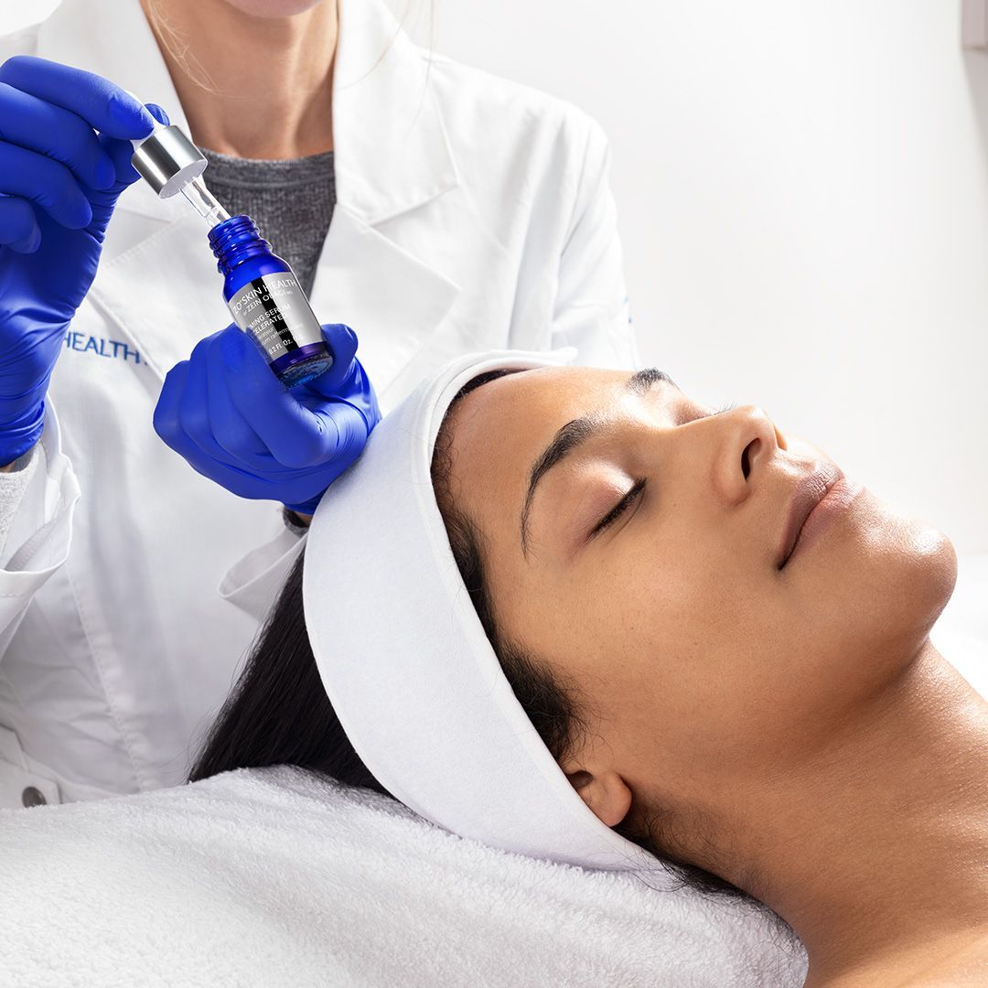 A woman is getting a facial treatment from a doctor