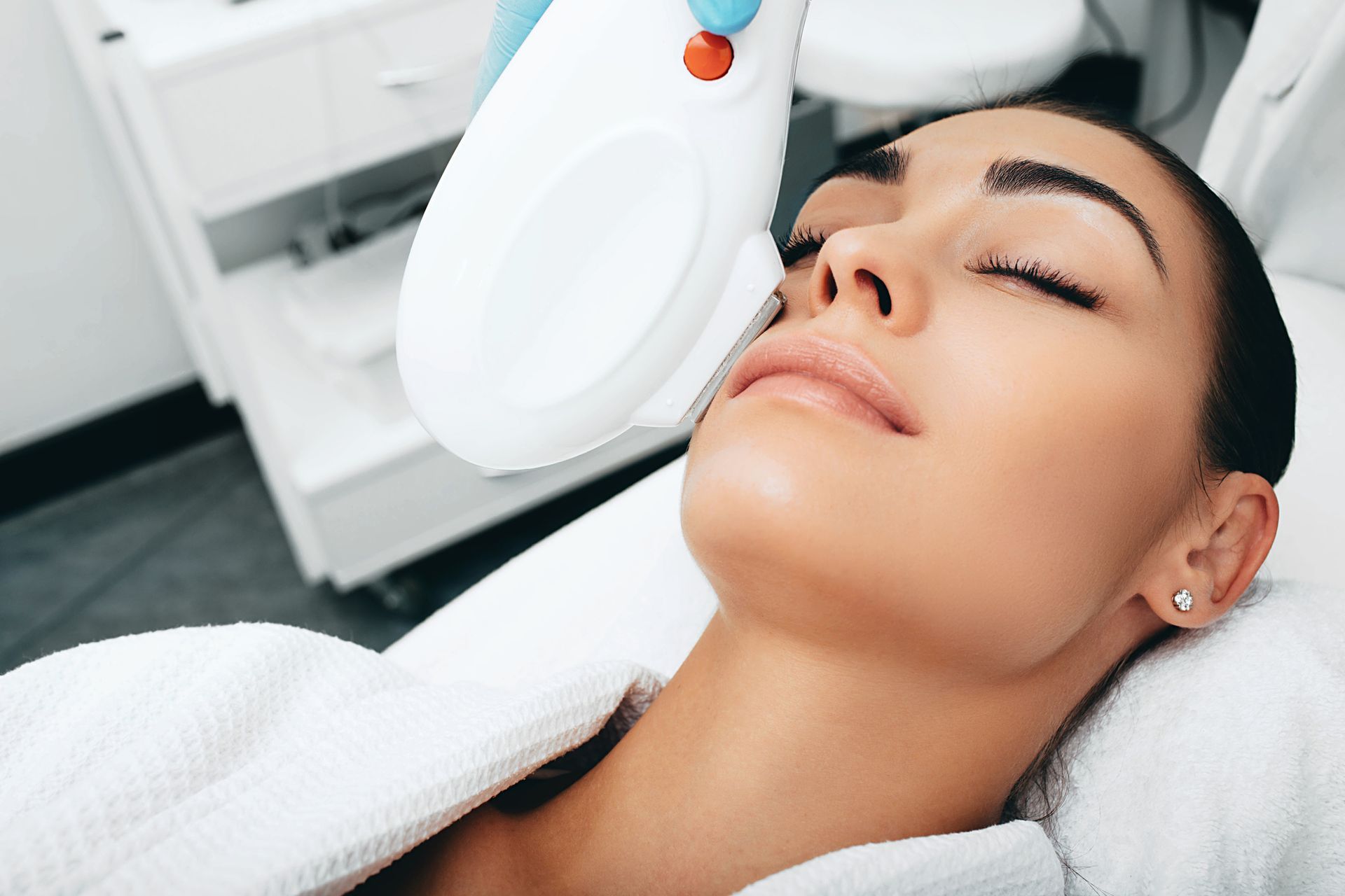 A woman is getting a laser treatment on her face.