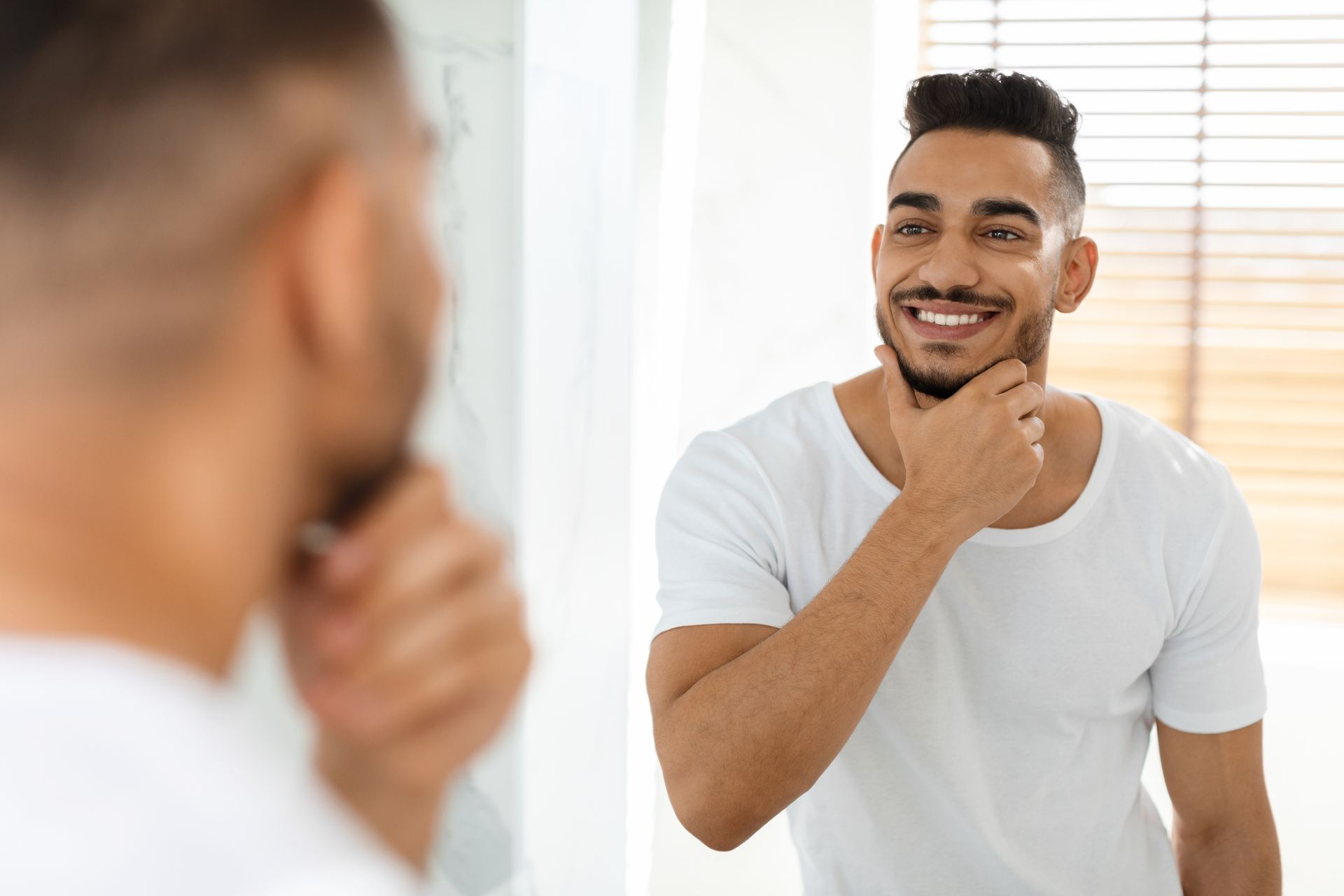 A man is brushing his teeth in front of a mirror.
