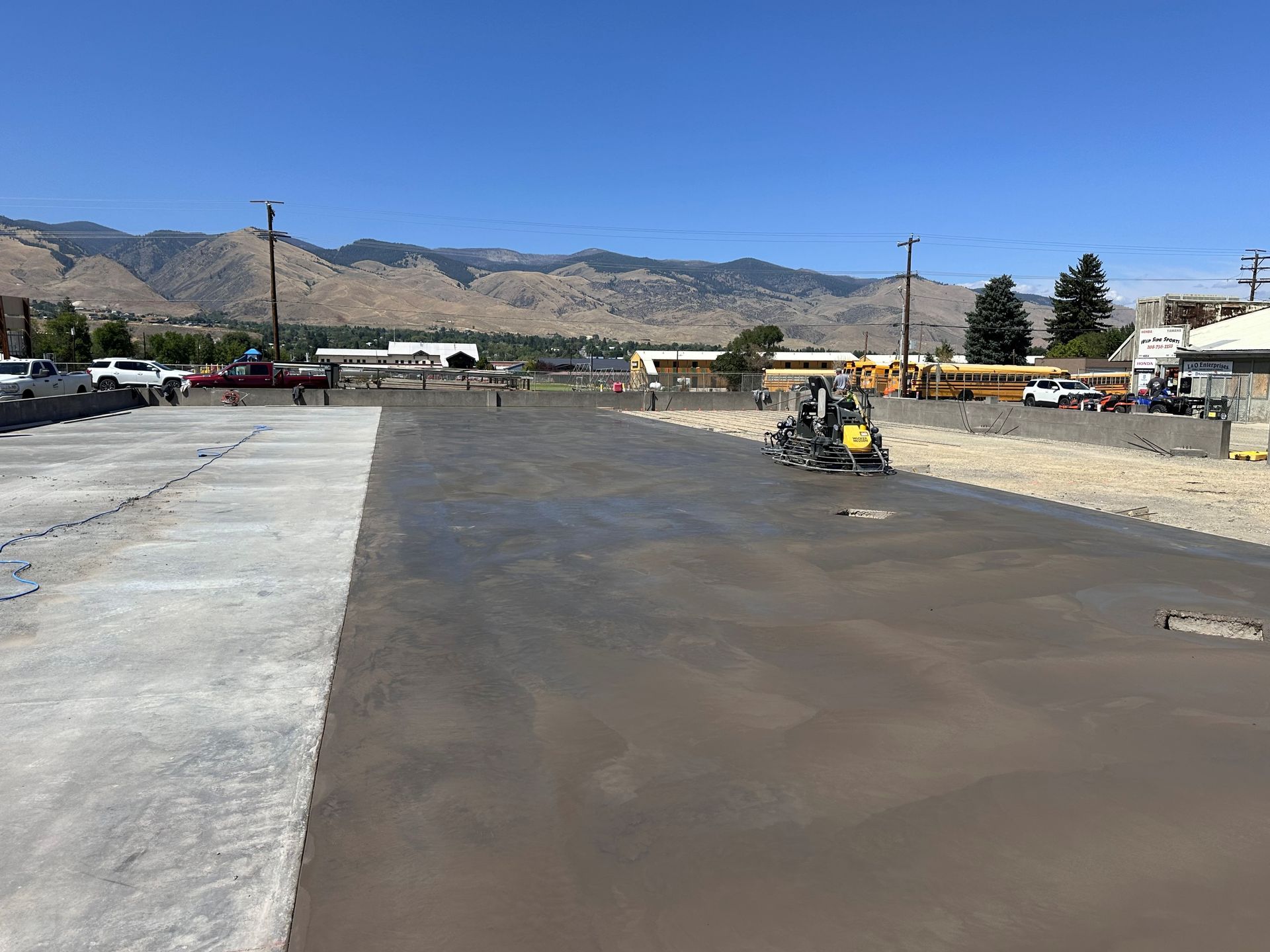 A construction site with a lot of concrete and mountains in the background.