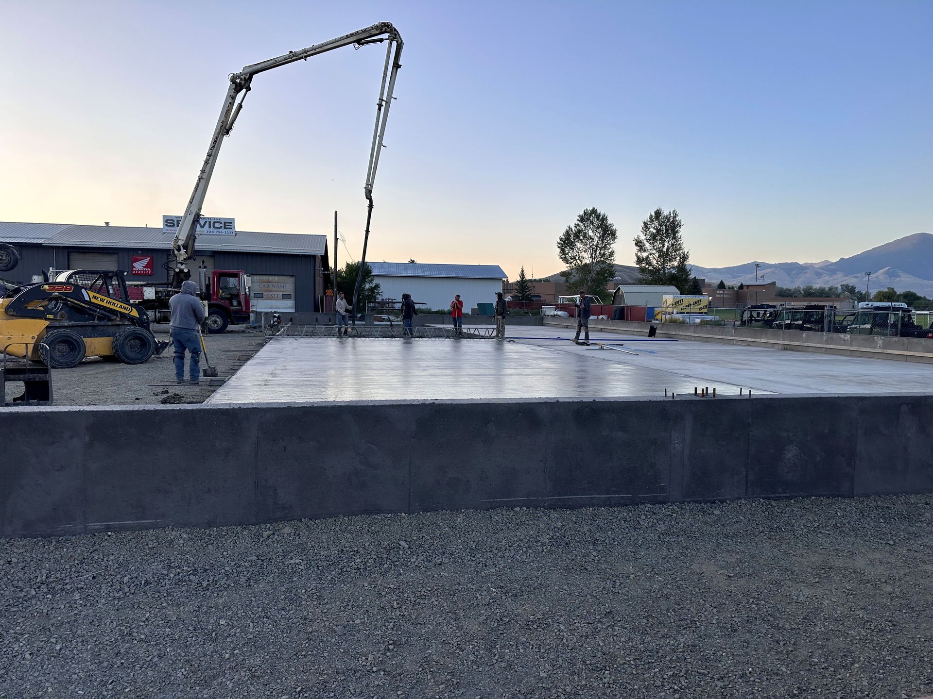 A man is laying concrete on the floor with a trowel.