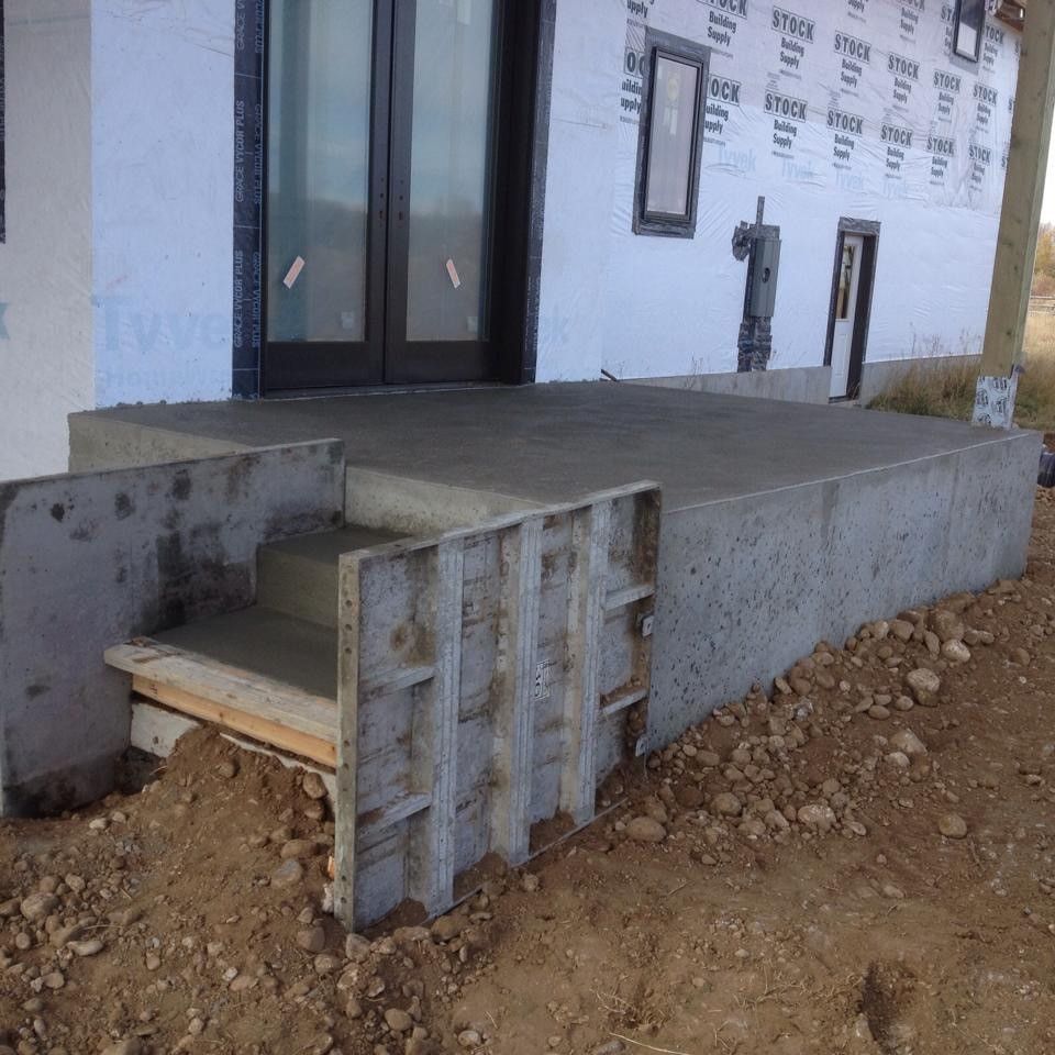 A concrete porch is being built in front of a house