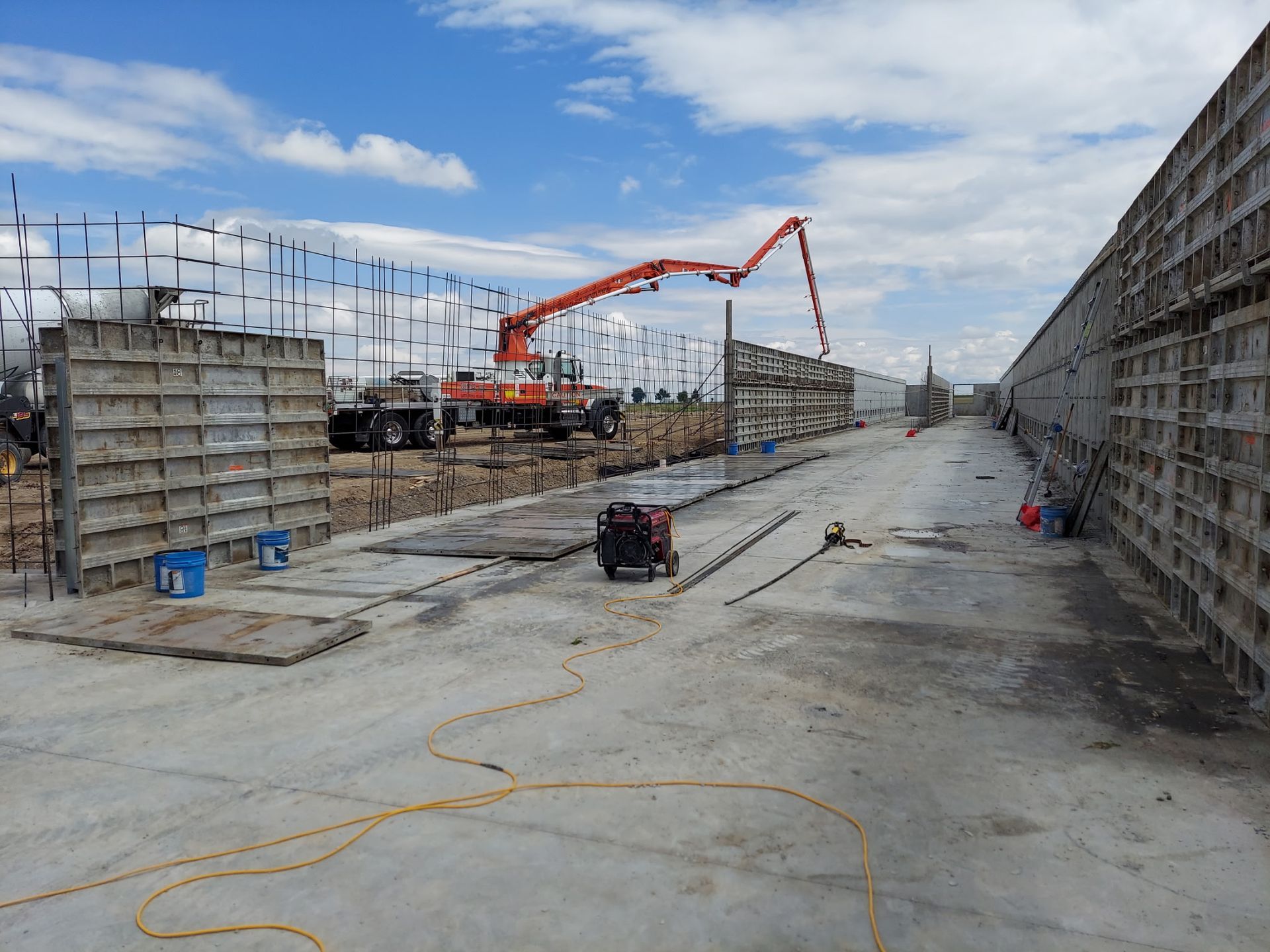 A person is pouring concrete into a pile of gravel.