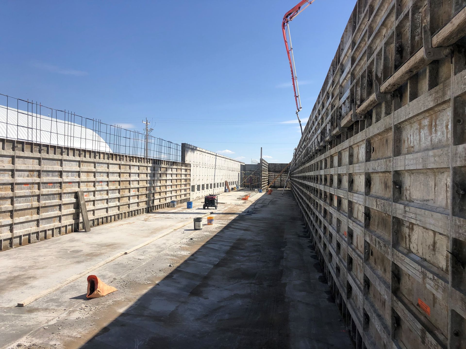 A large concrete wall is being built on a construction site.