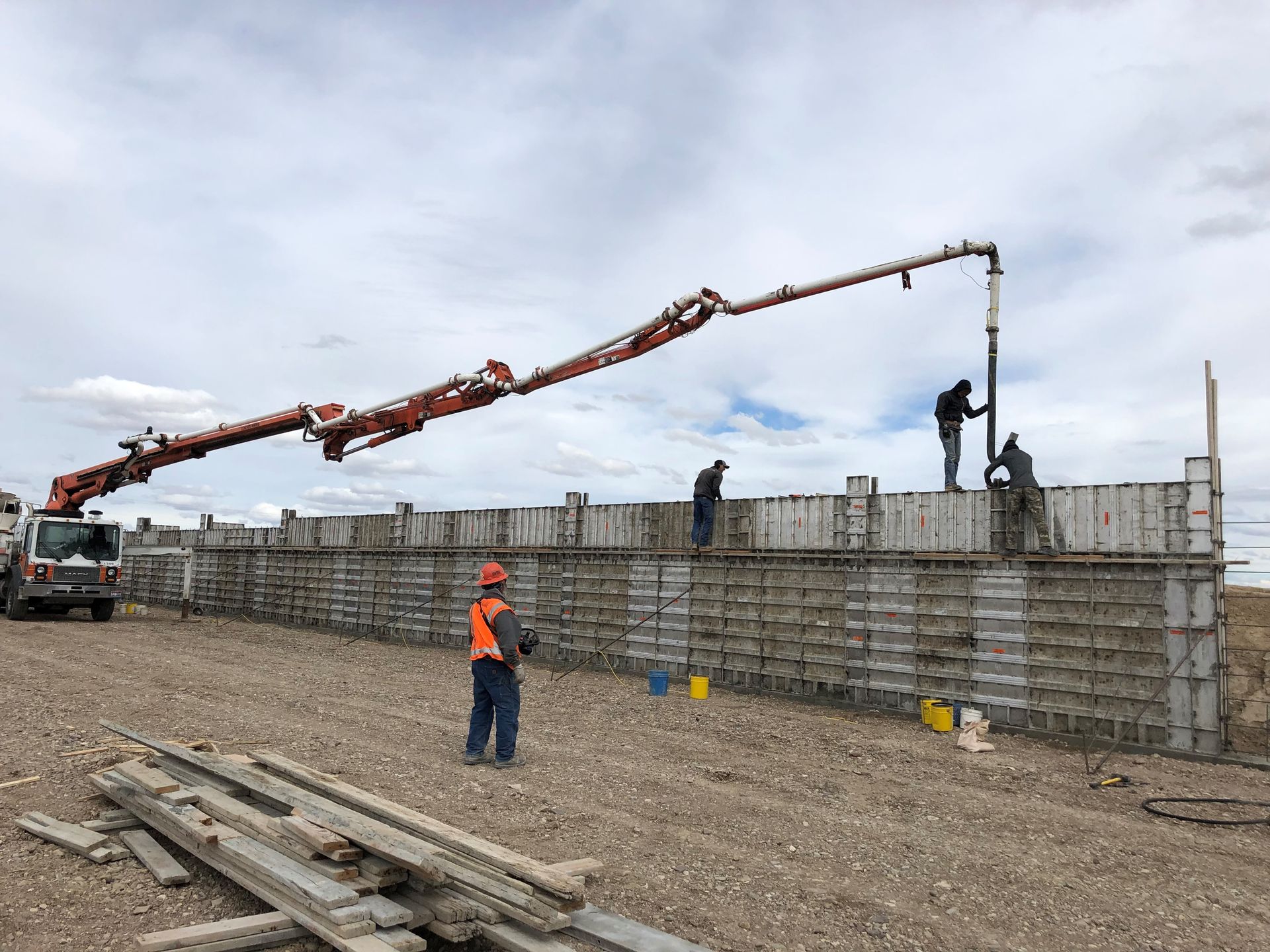 A concrete pump is being used to pour concrete into a wall.