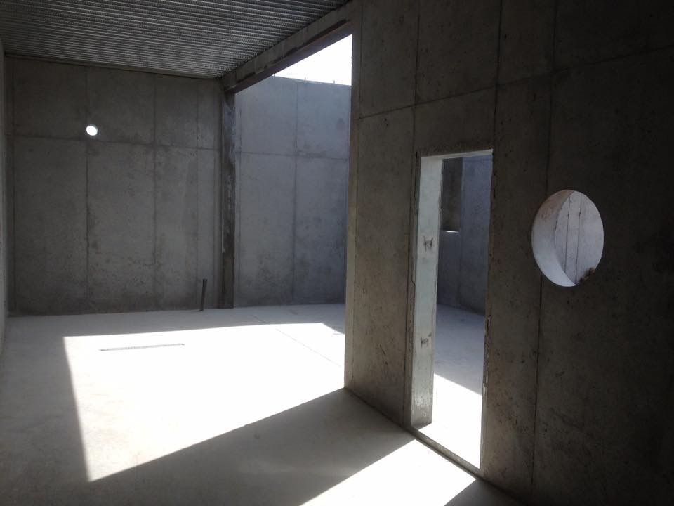 A man is raking concrete on a construction site.