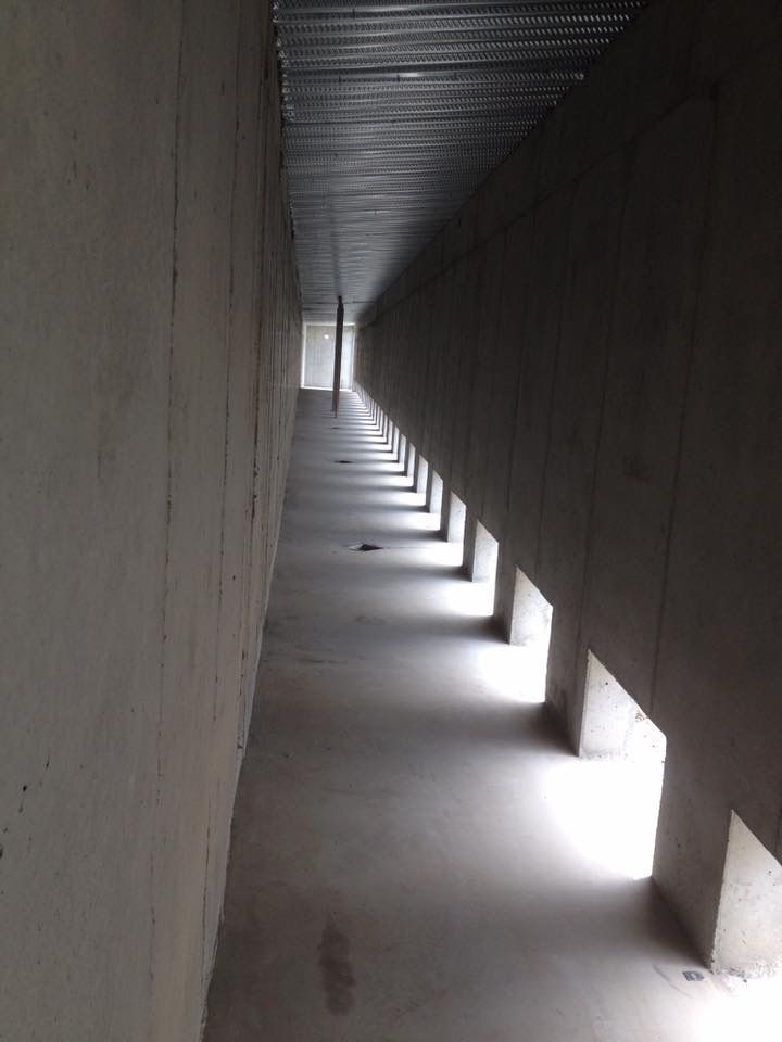 A man is using a broom to spread concrete on a sidewalk