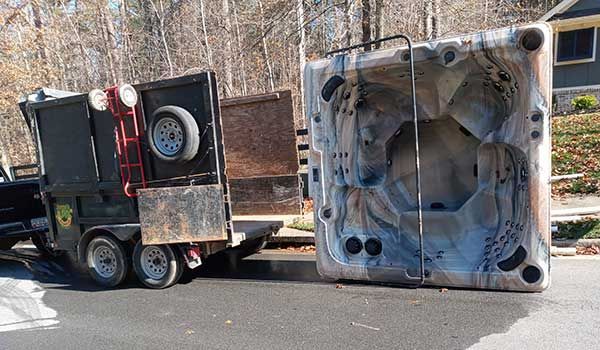 A hot tub is being towed by a truck.