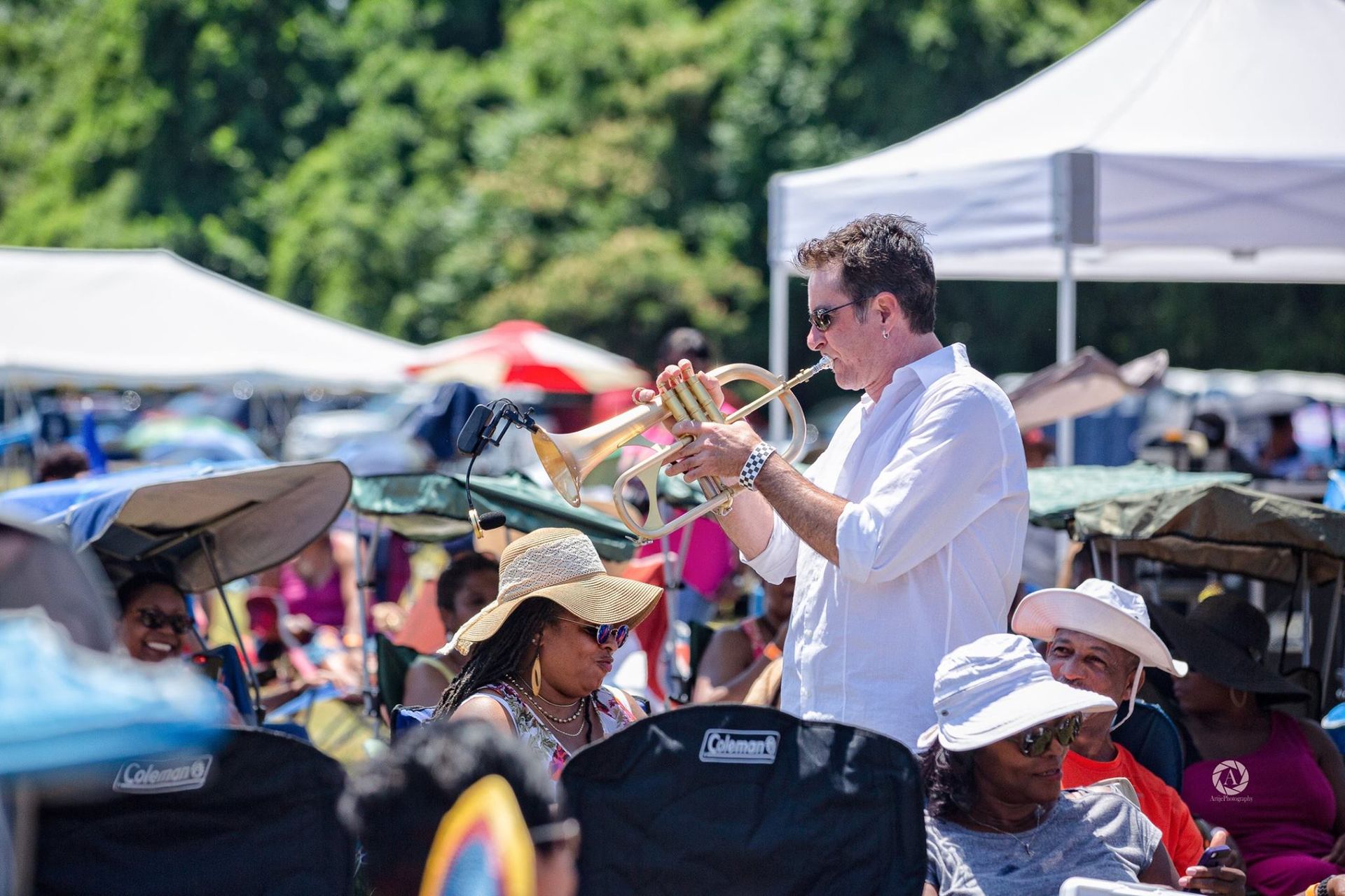 Rob Zinn playing a trumpet in front of a crowd at a festival.