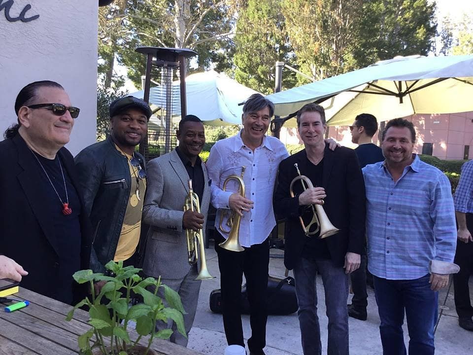 A group of men standing next to each other holding trumpets with Rob Zinn and Rick Braun