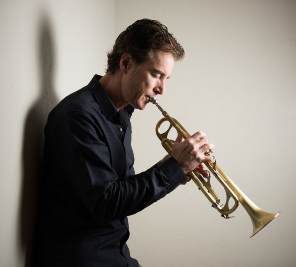 Smooth Jazz Trumpeter Rob Zinn in a black shirt is playing a trumpet