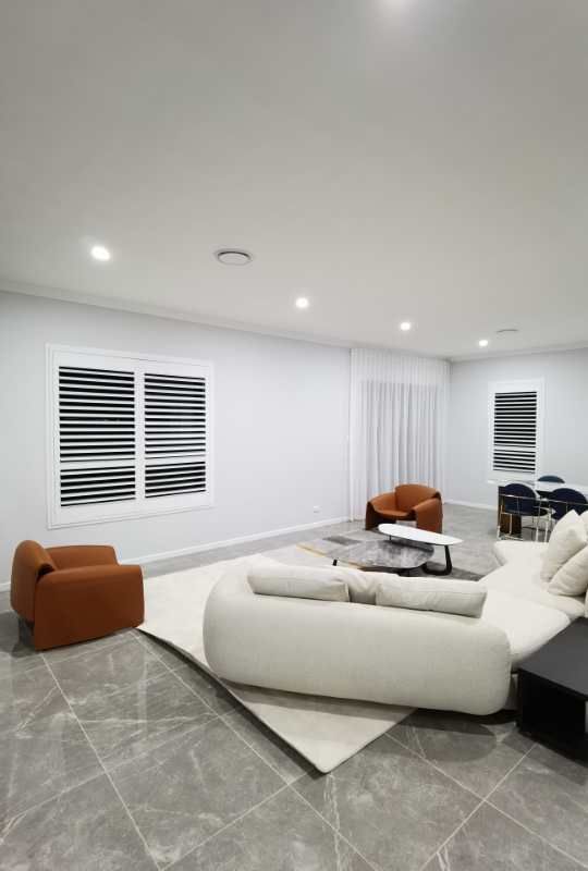 A living room with a couch , chairs , and a table.