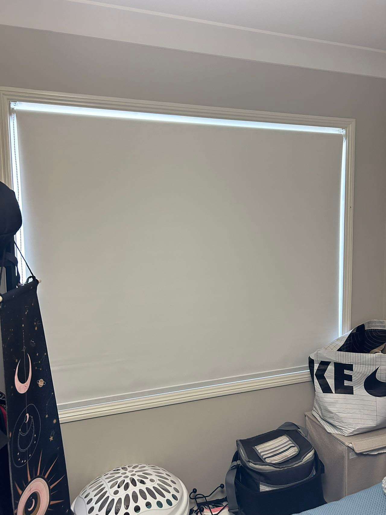 A bedroom with a large window and a bed.