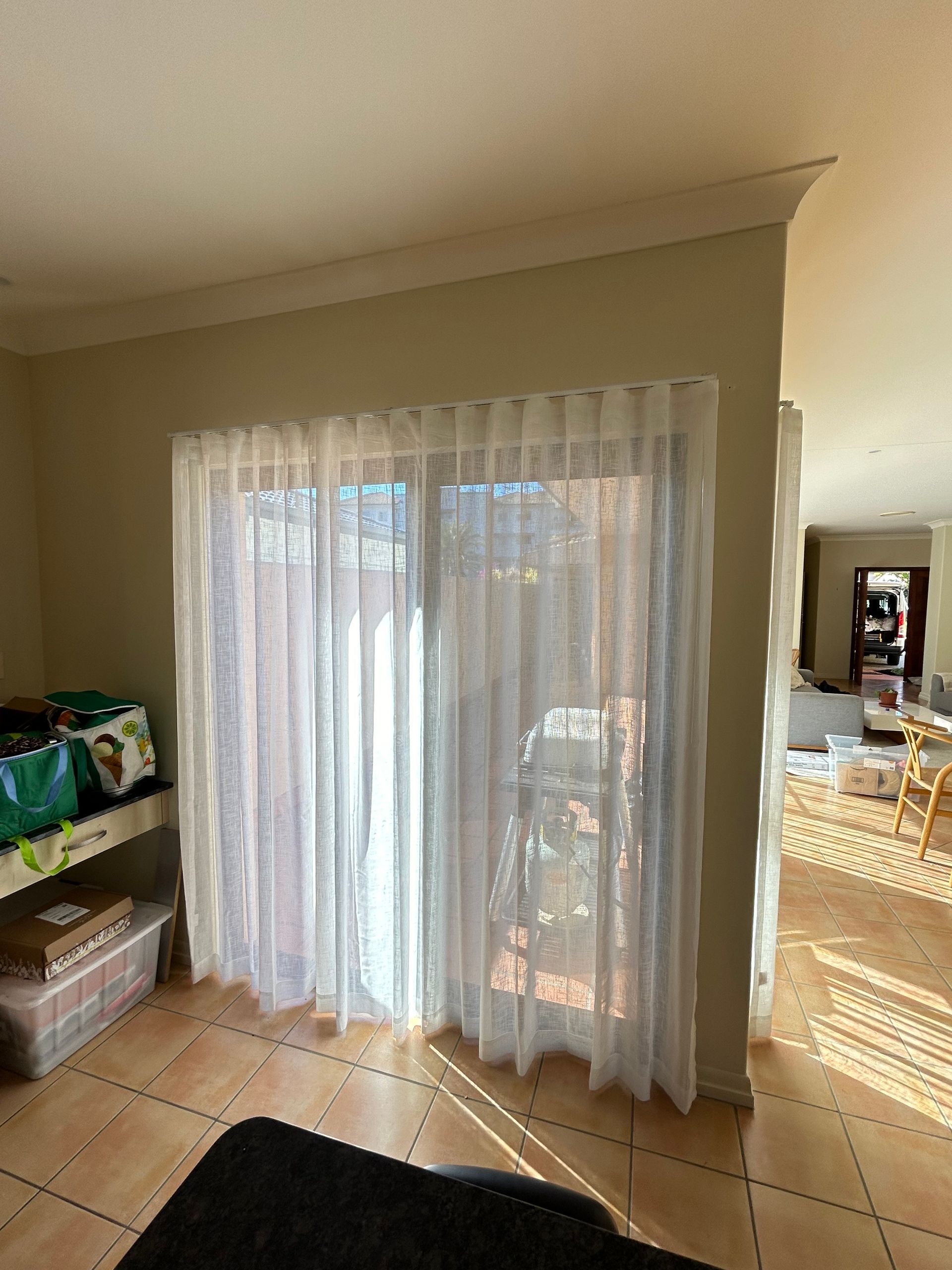 A living room with a sliding glass door and white curtains.