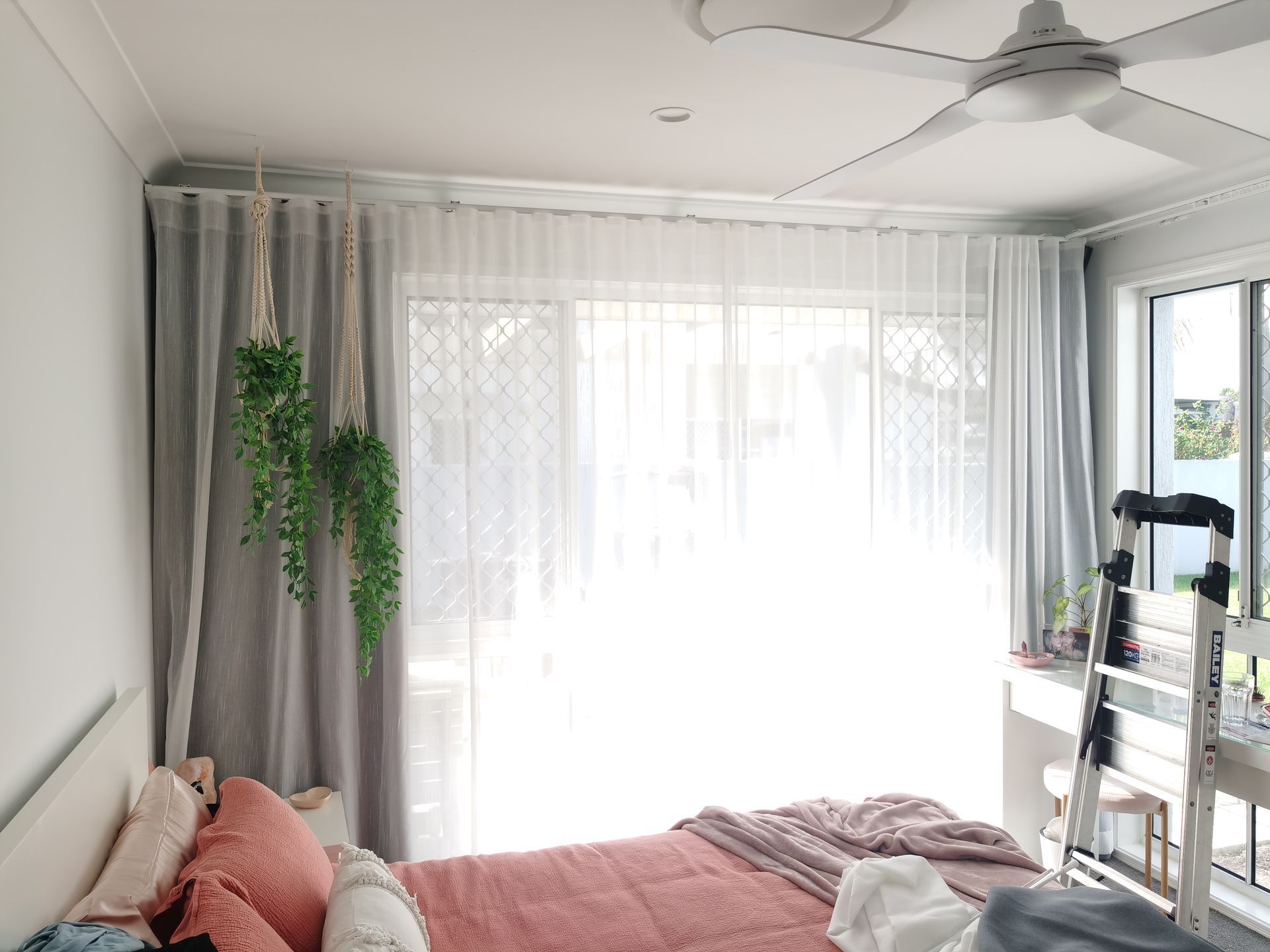 A bedroom with a bed and a ceiling fan.