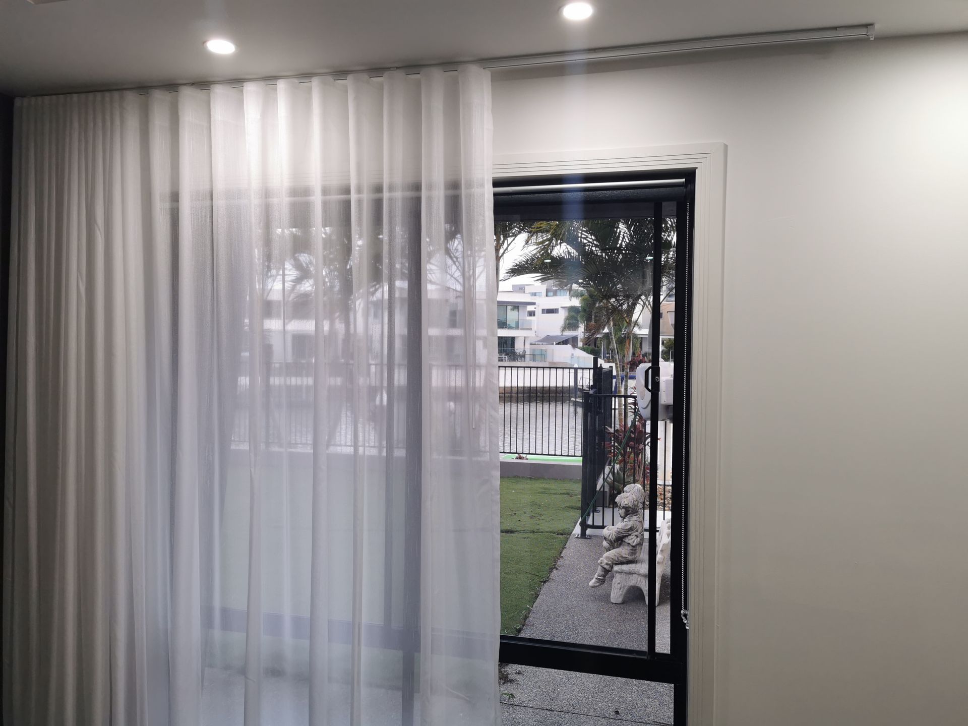 A room with a sliding glass door and white curtains.