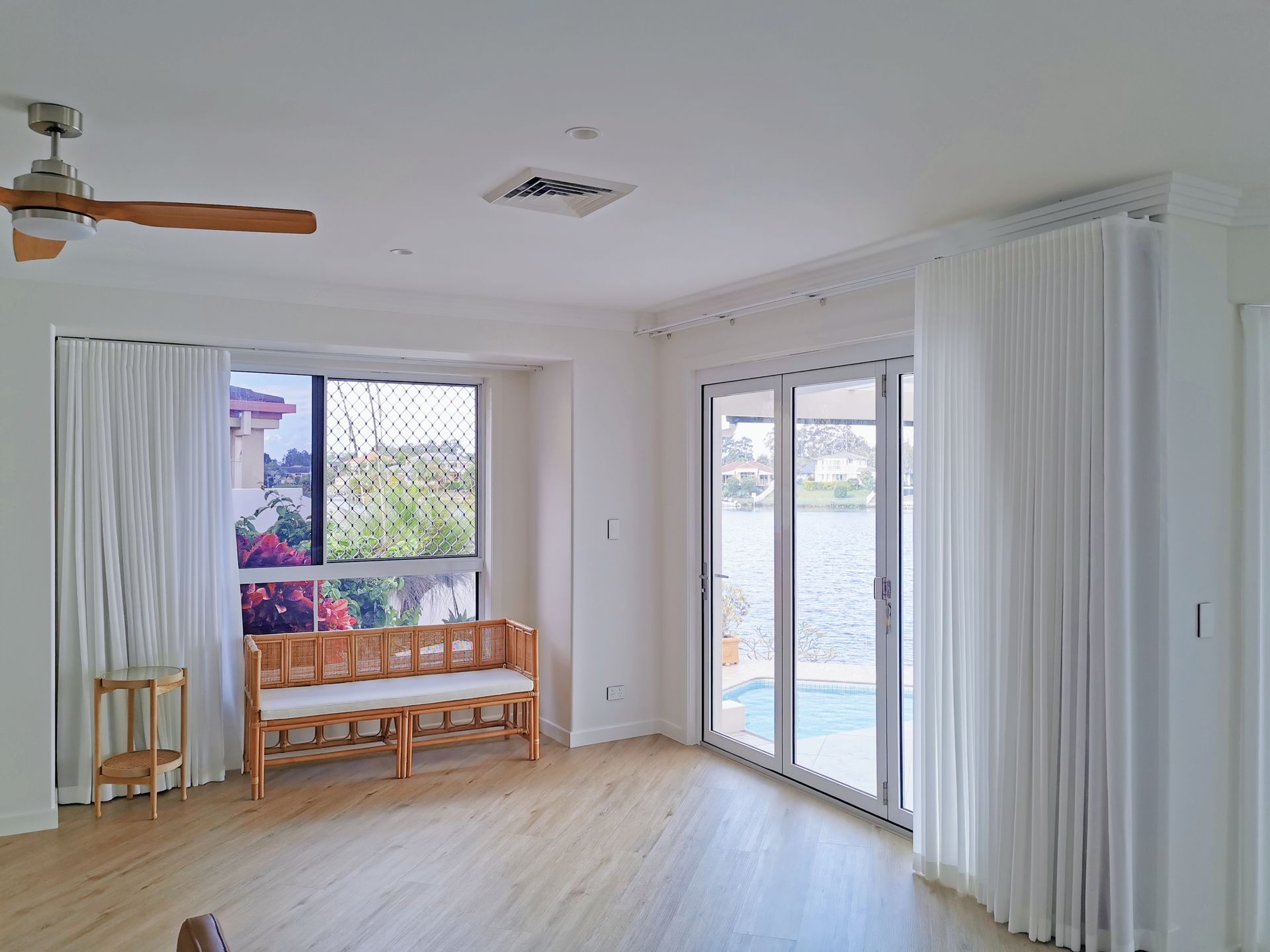 A living room with a bench and a ceiling fan