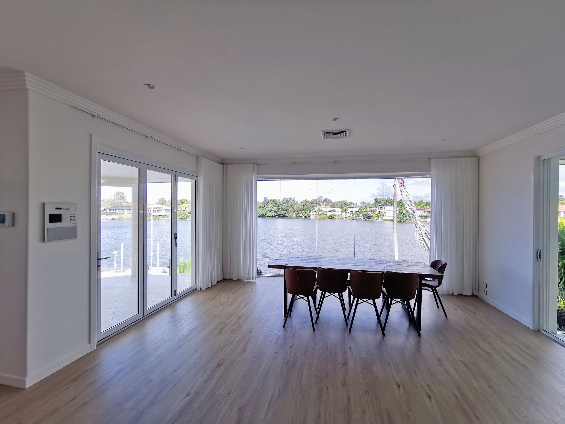 A large dining room with a table and chairs and a view of the water.