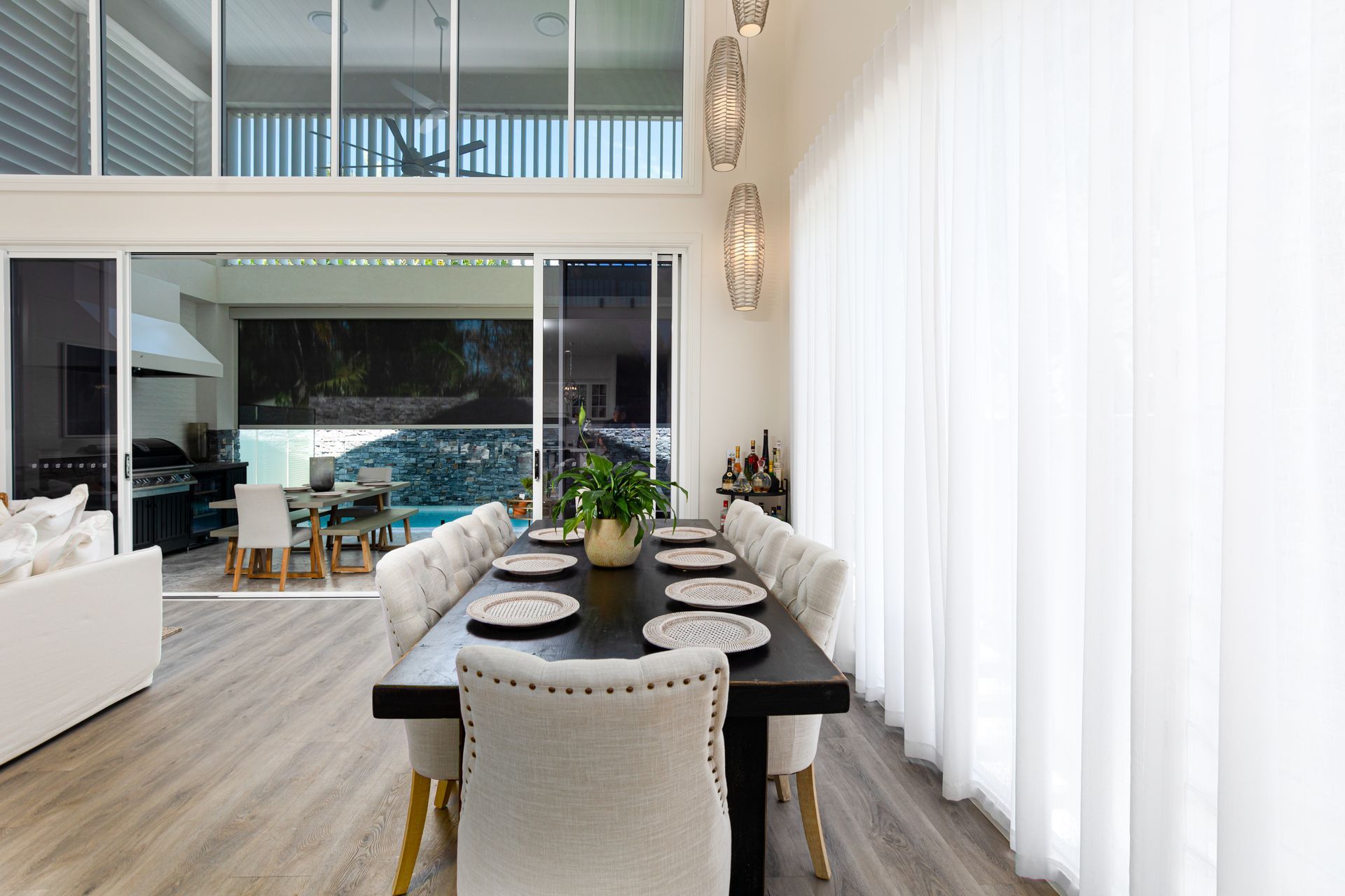 A dining room with a long table and chairs and a large window.