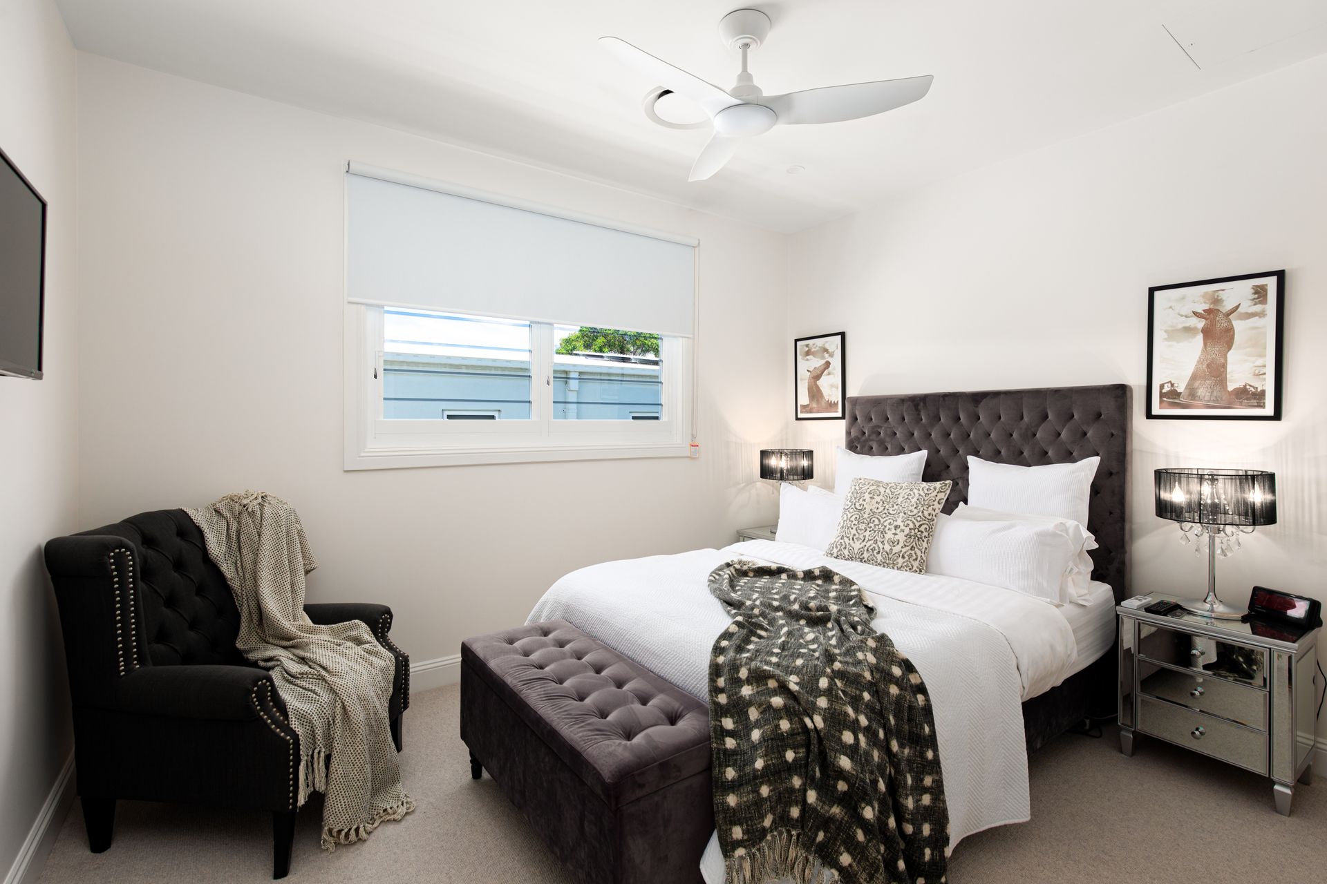 A bedroom with a large bed and a chair