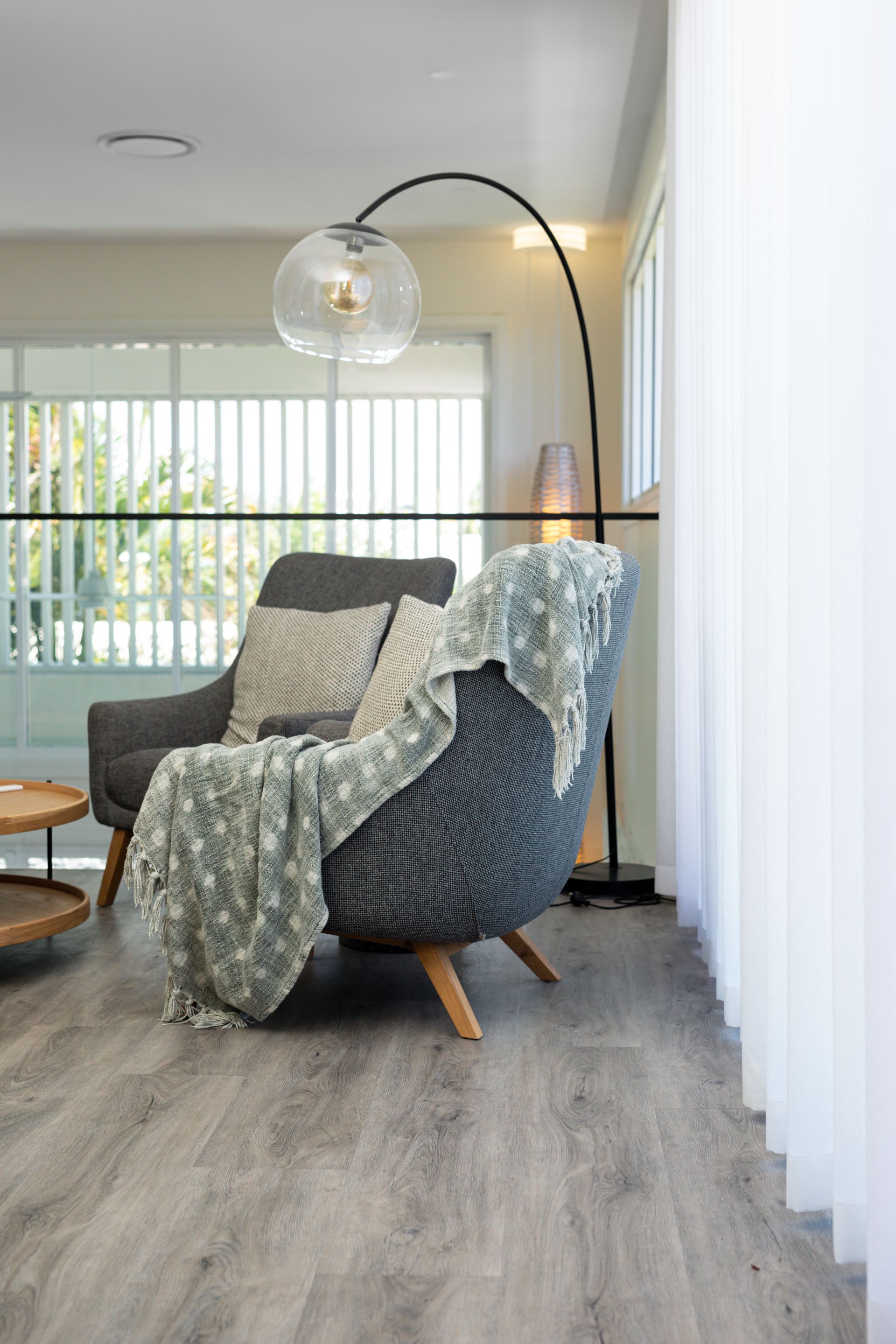 There is a chair with a blanket on it in the living room.