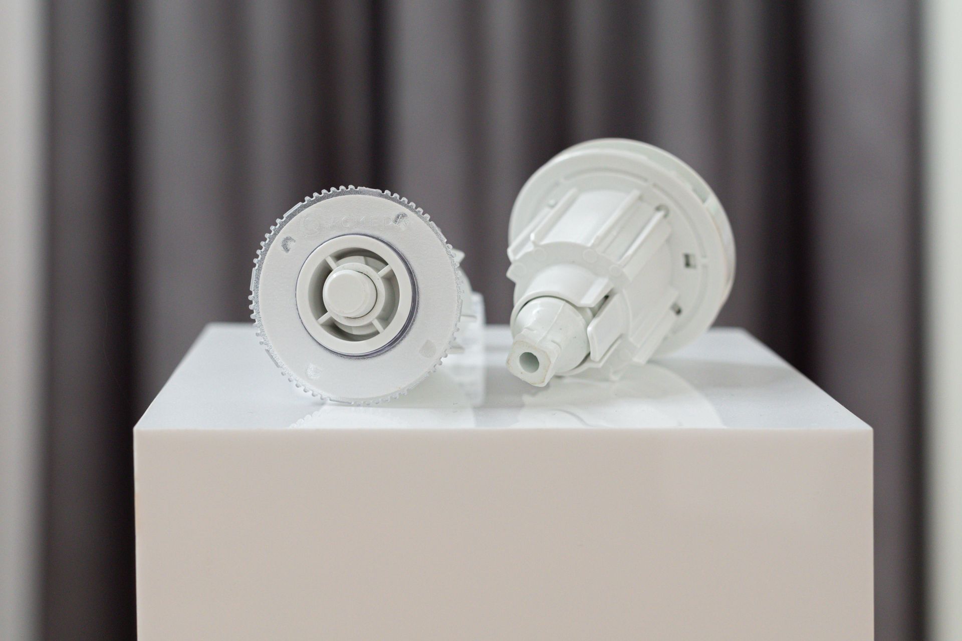 Two white objects are sitting on top of a white box.