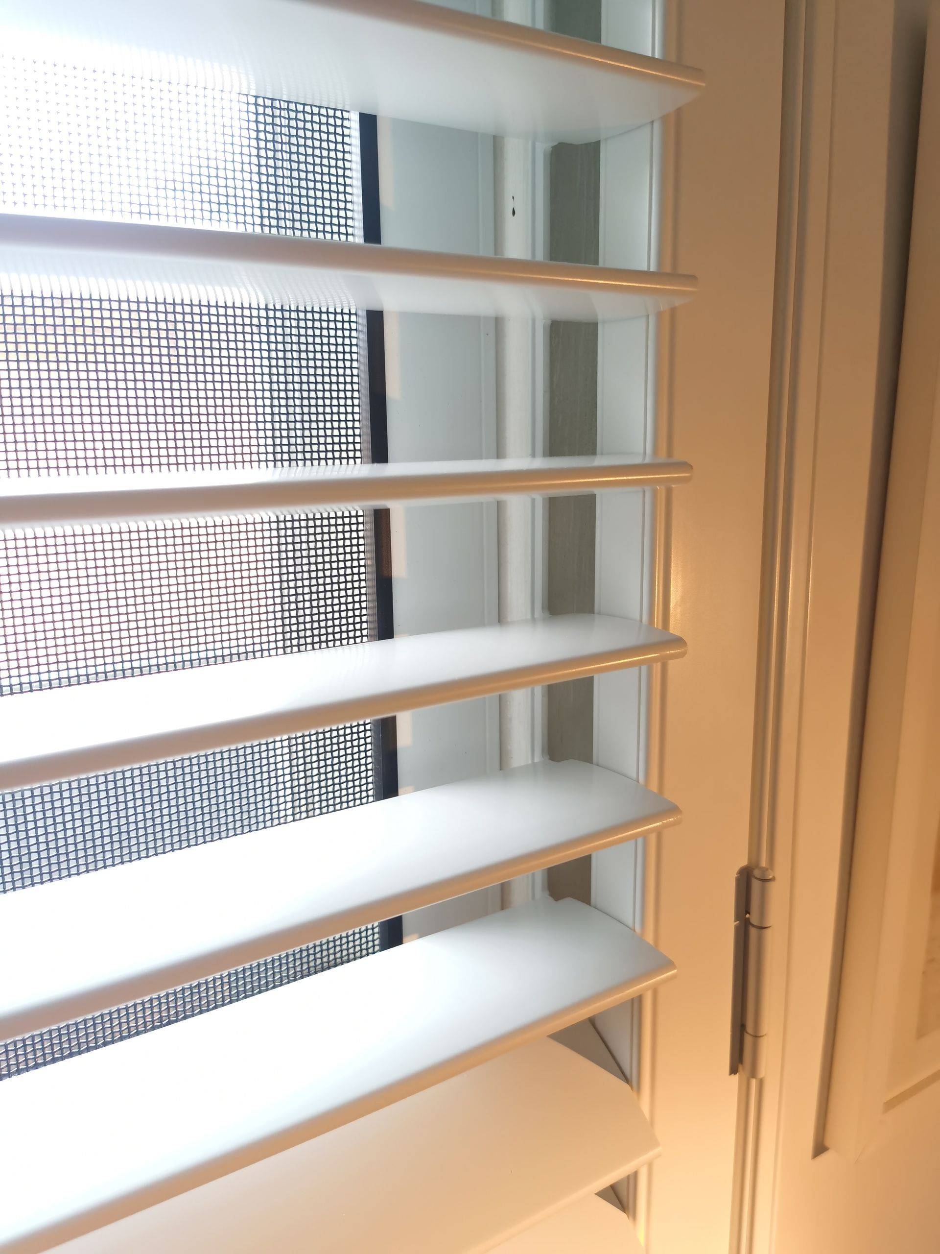 A close up of a window with shutters on it