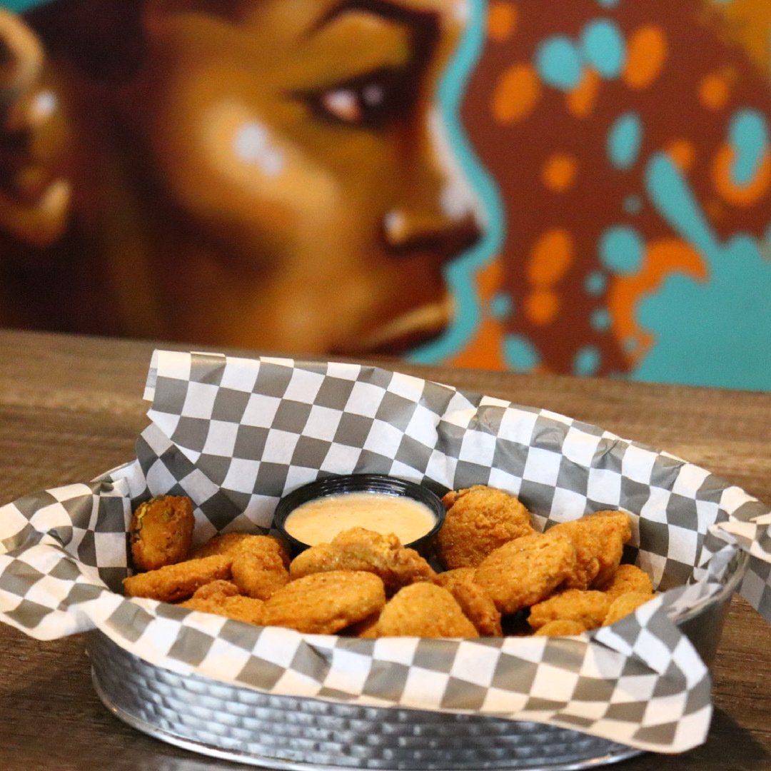 A basket of chicken nuggets with a dipping sauce