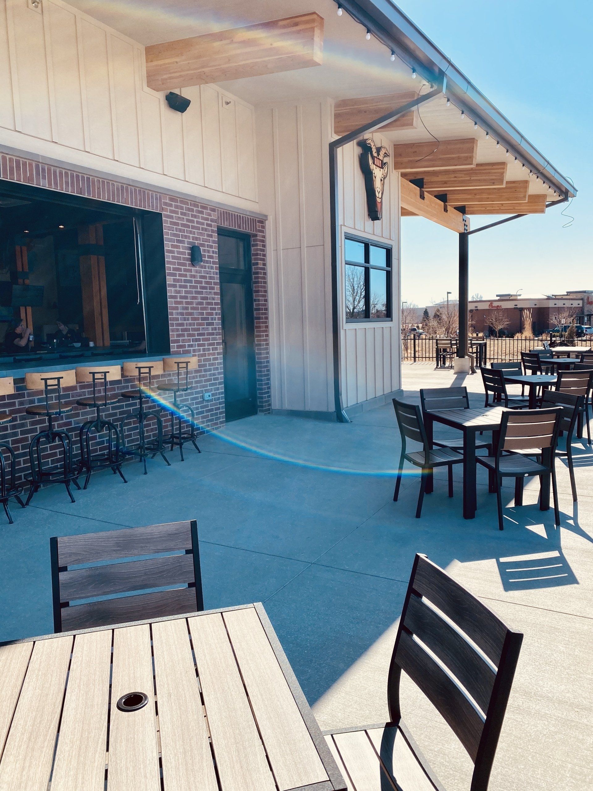 A restaurant with tables and chairs outside on a sunny day
