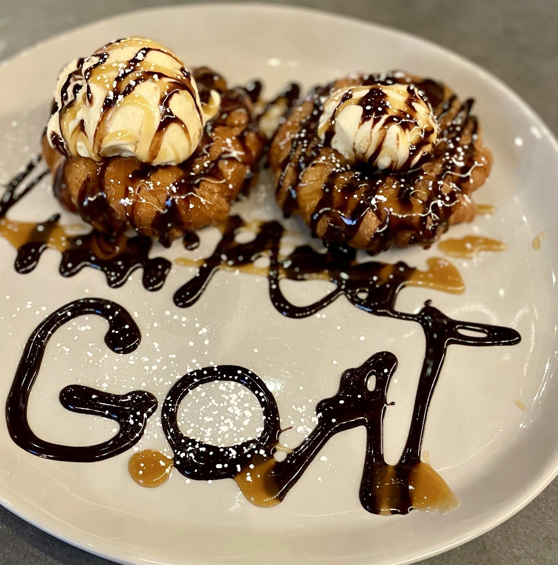 A plate of food with the word goat written on it