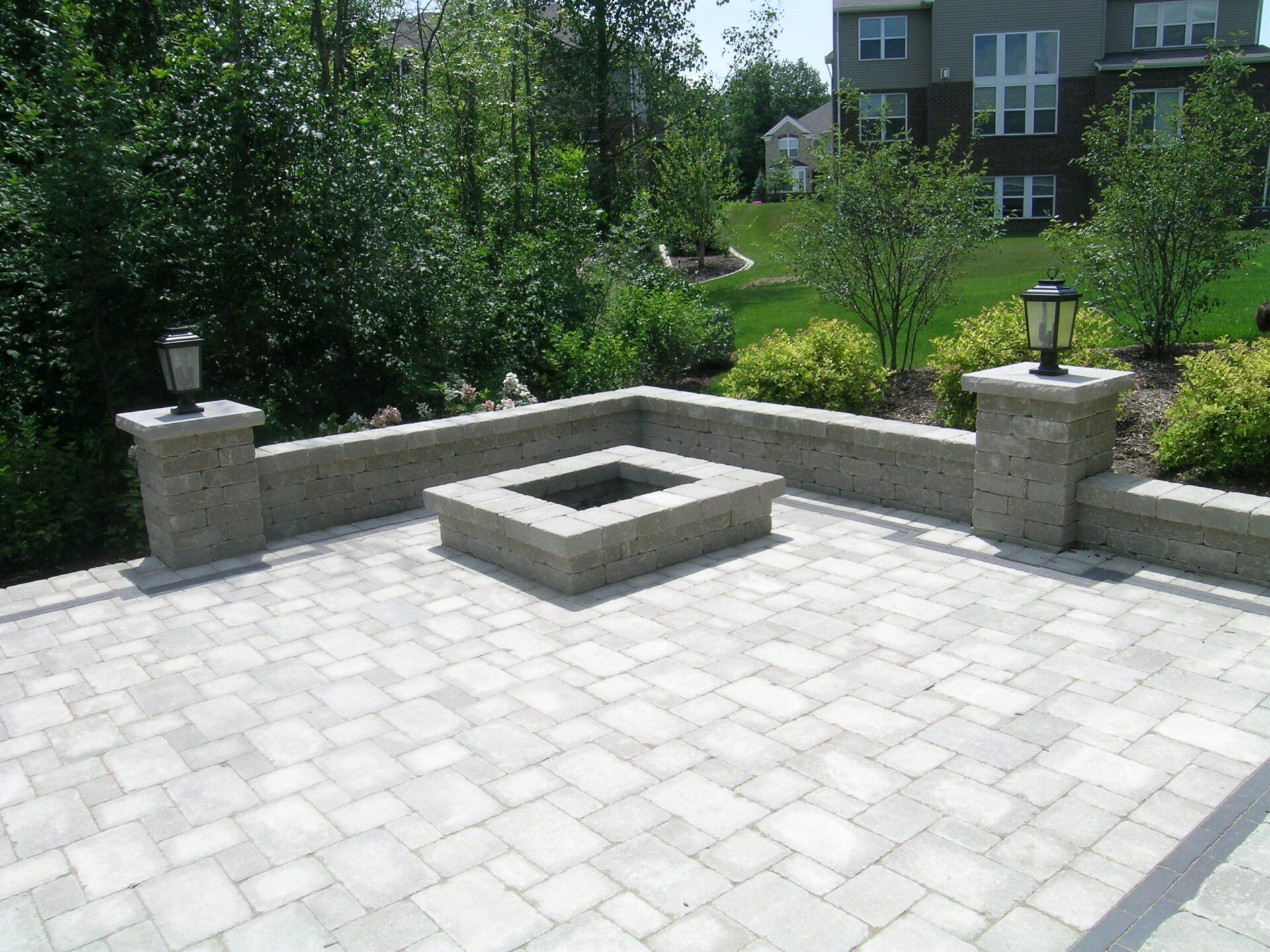 A brick patio with a fire pit in the middle