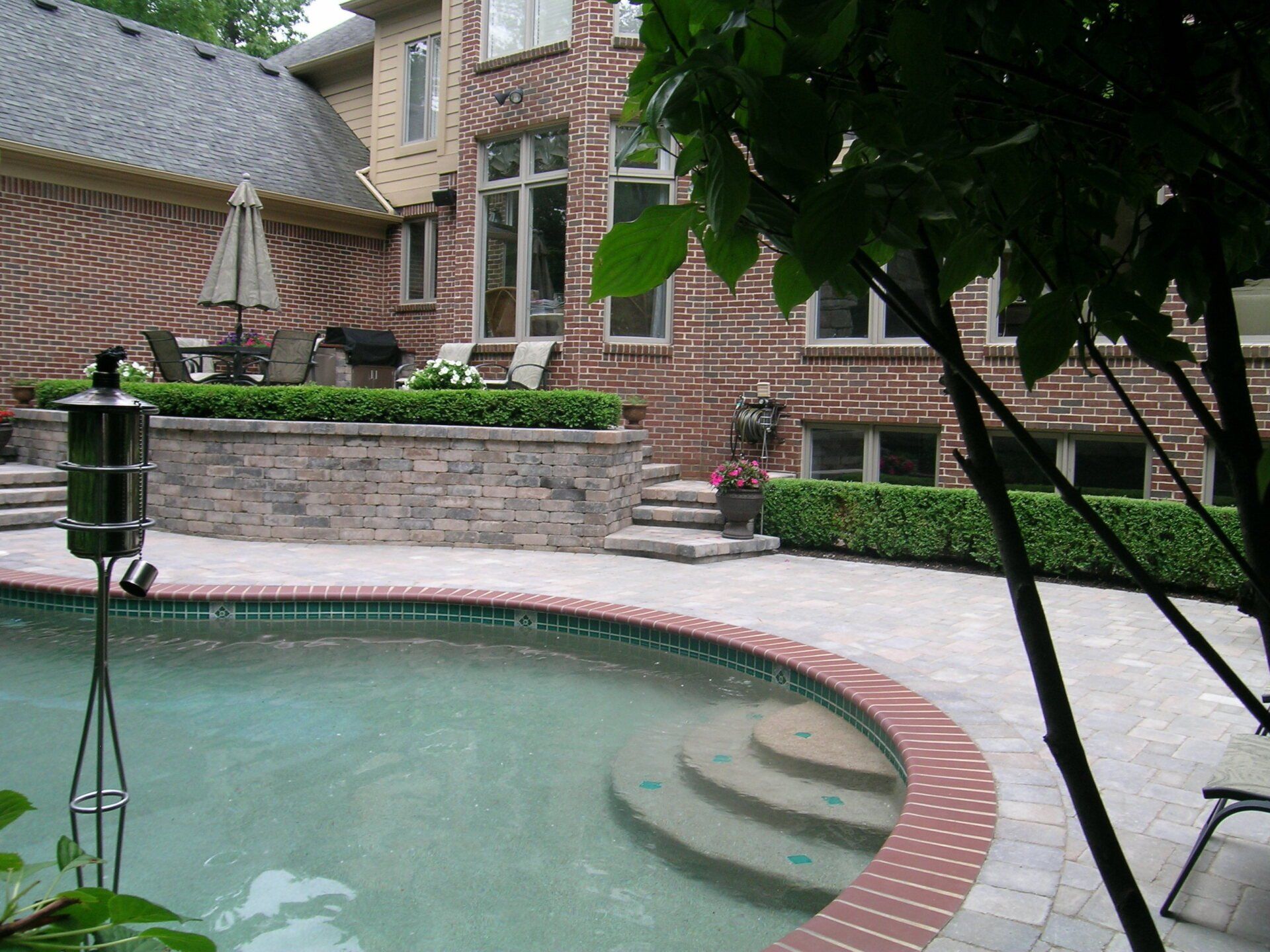 A brick house with a swimming pool in front of it