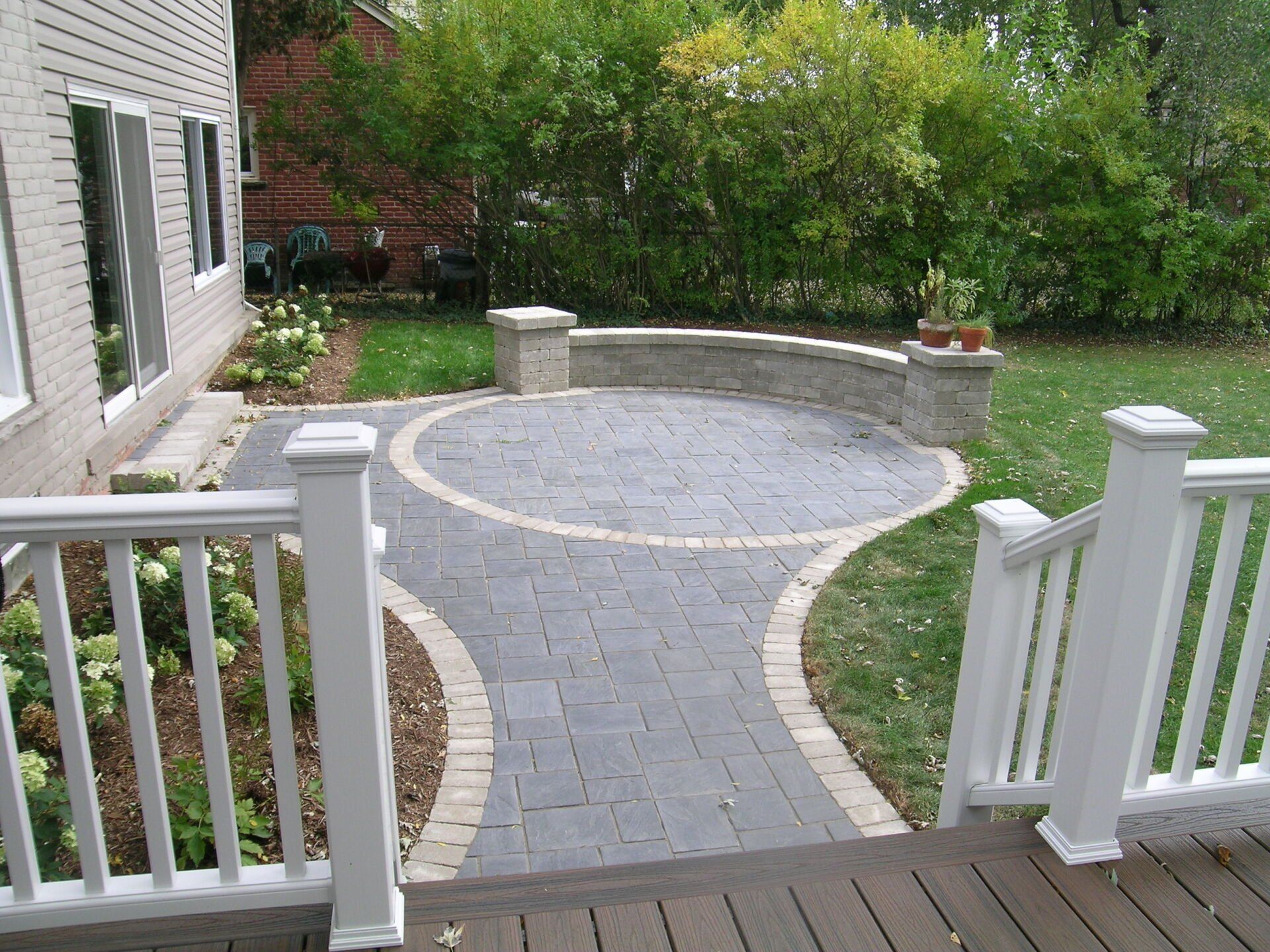 A walkway leading to a patio with a white railing