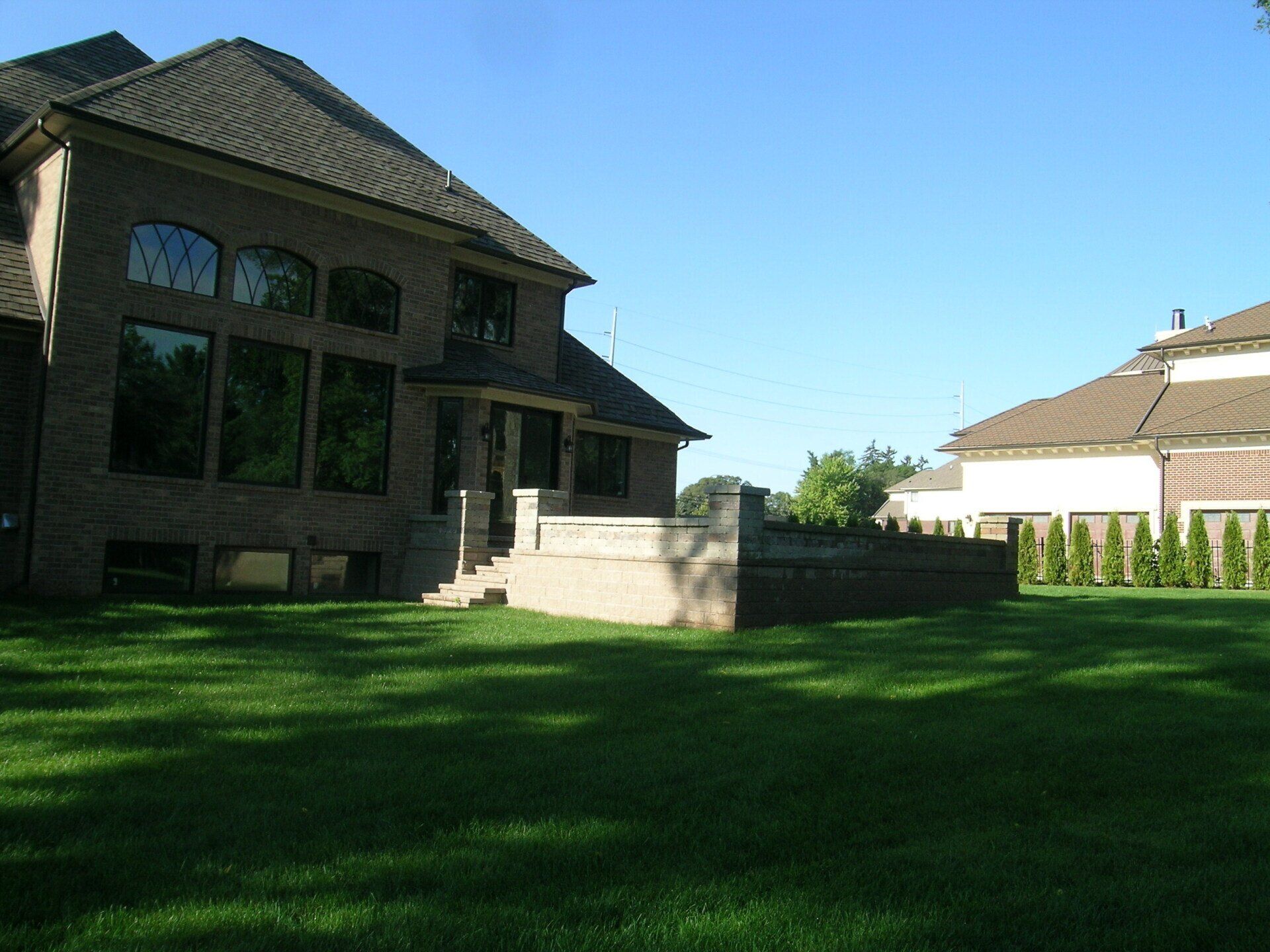 A large brick house with a large lawn in front of it