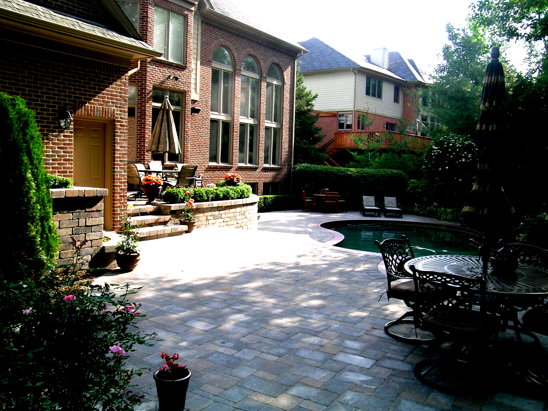 A large brick house with a swimming pool in front of it