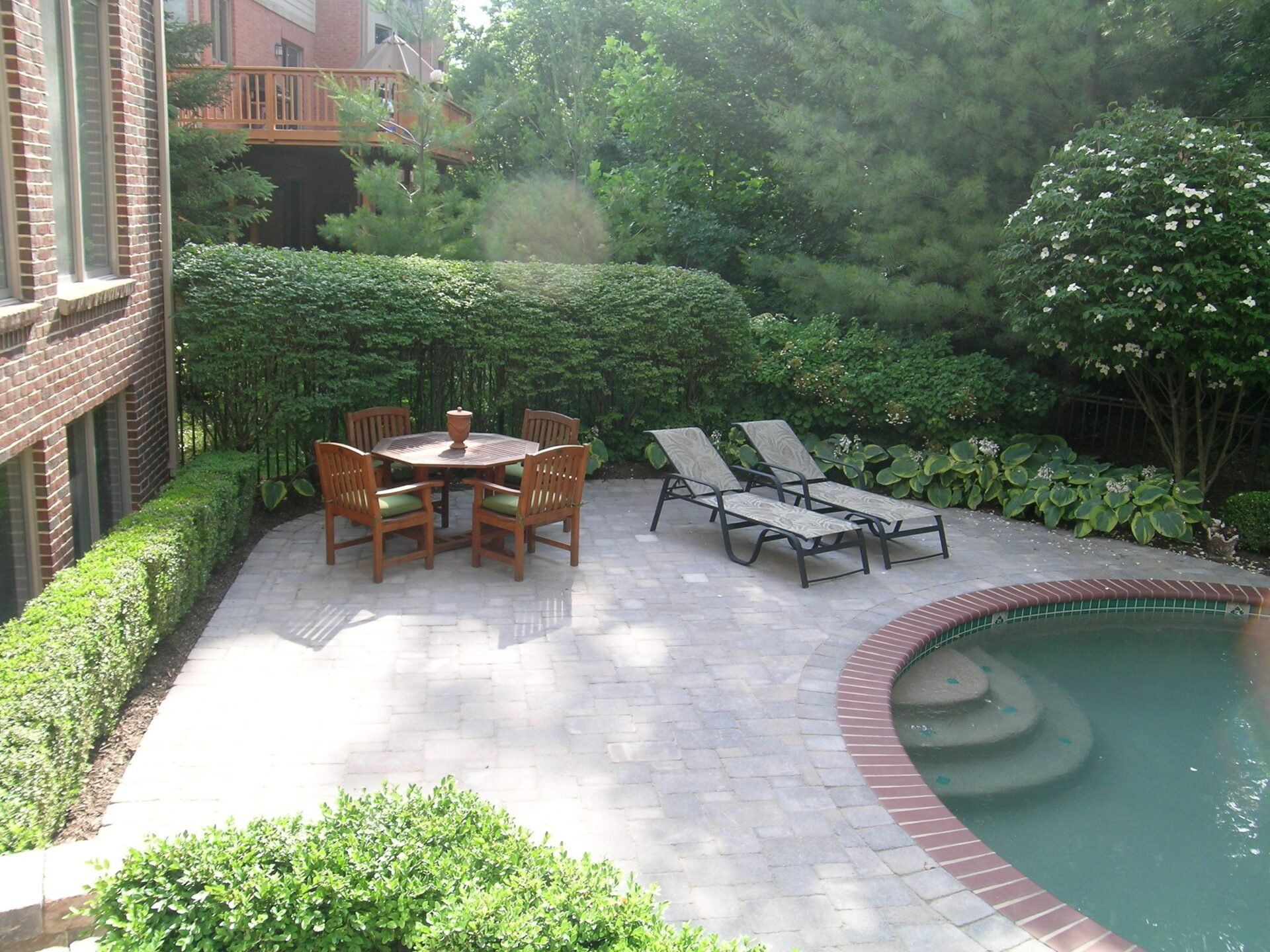 A patio with a table and chairs next to a swimming pool