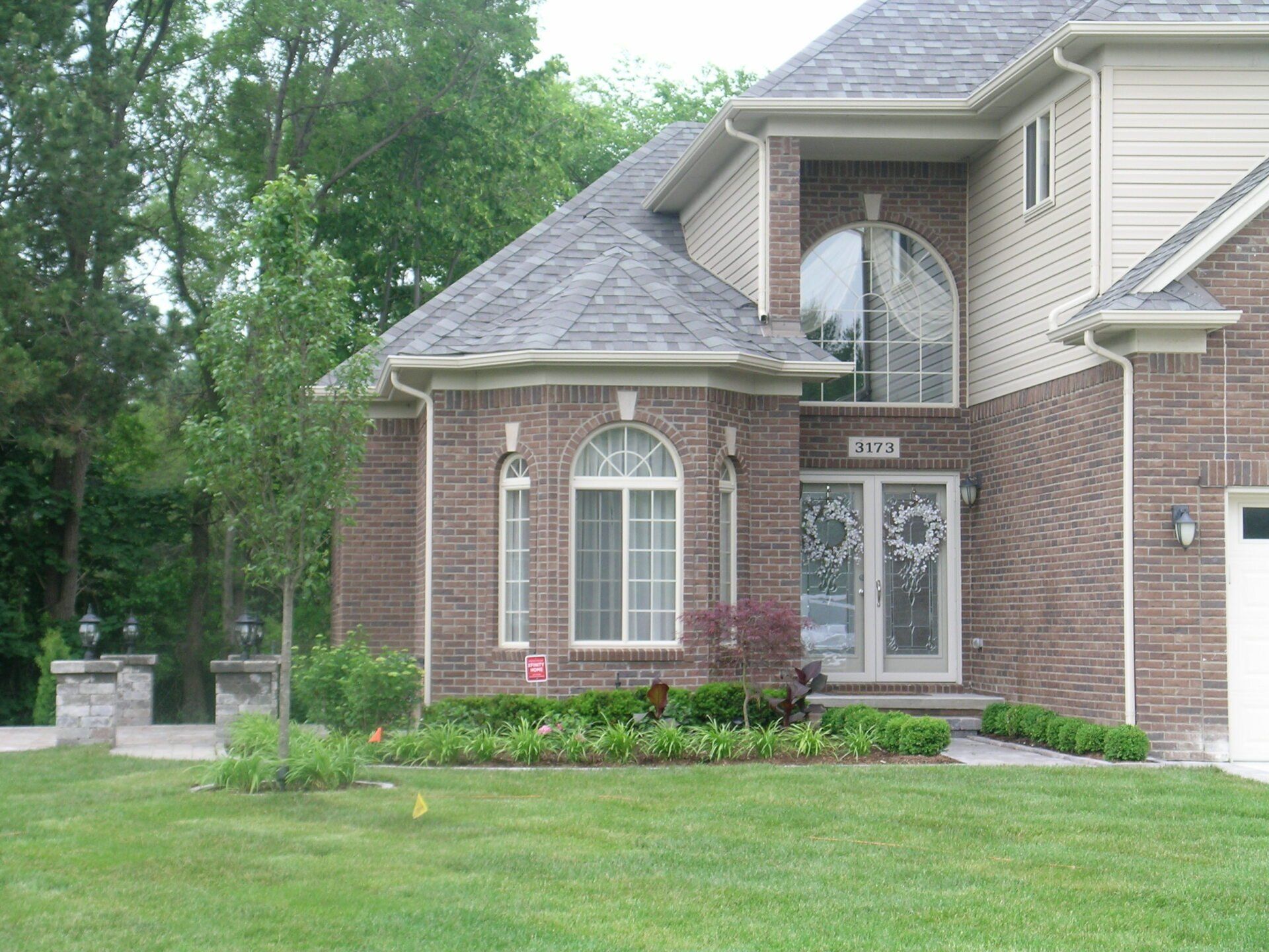 A large brick house with a lawn in front of it