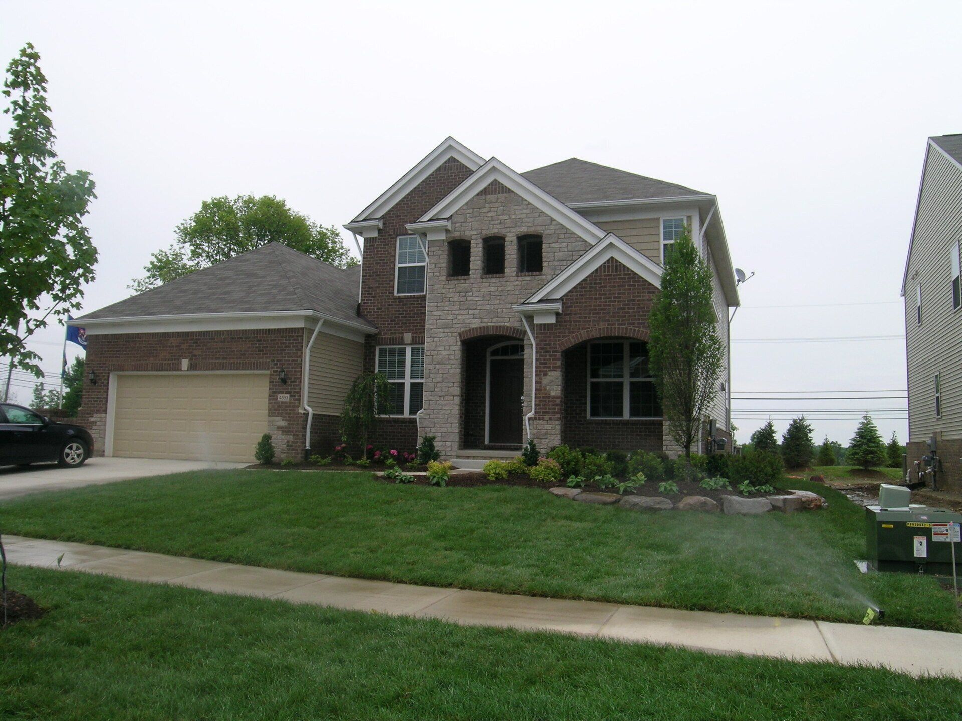 A large brick house with a tan garage door