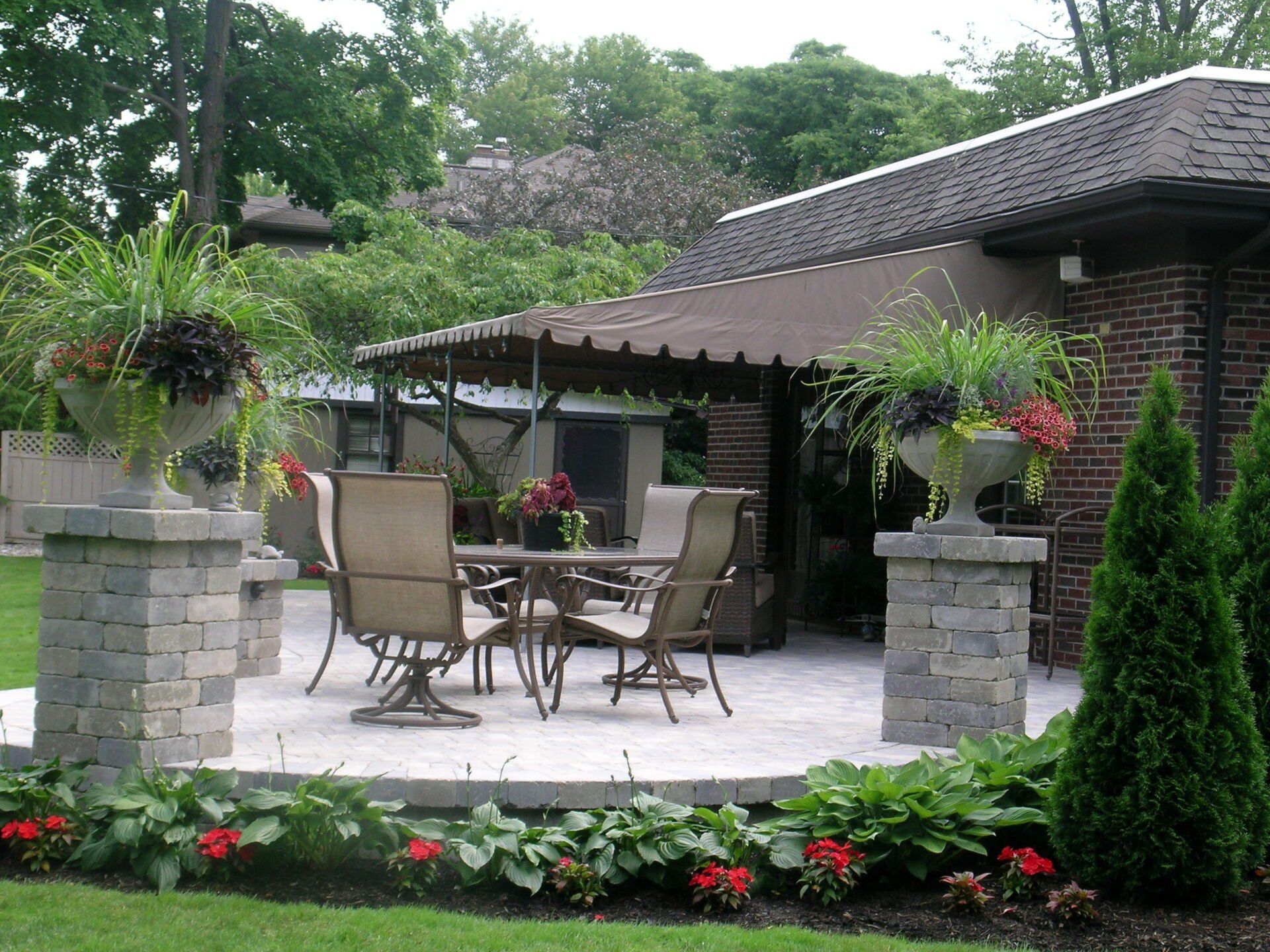 A patio with a table and chairs in front of a house