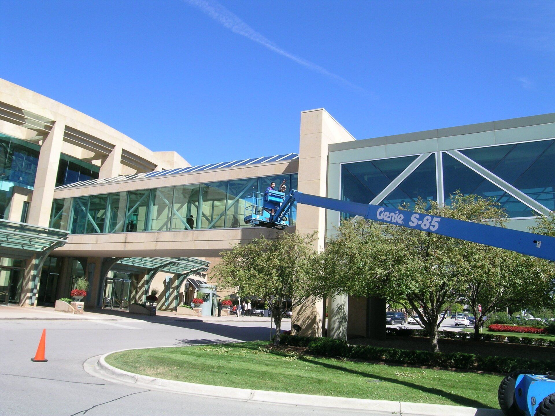A genie lift is being used to clean the windows of a building