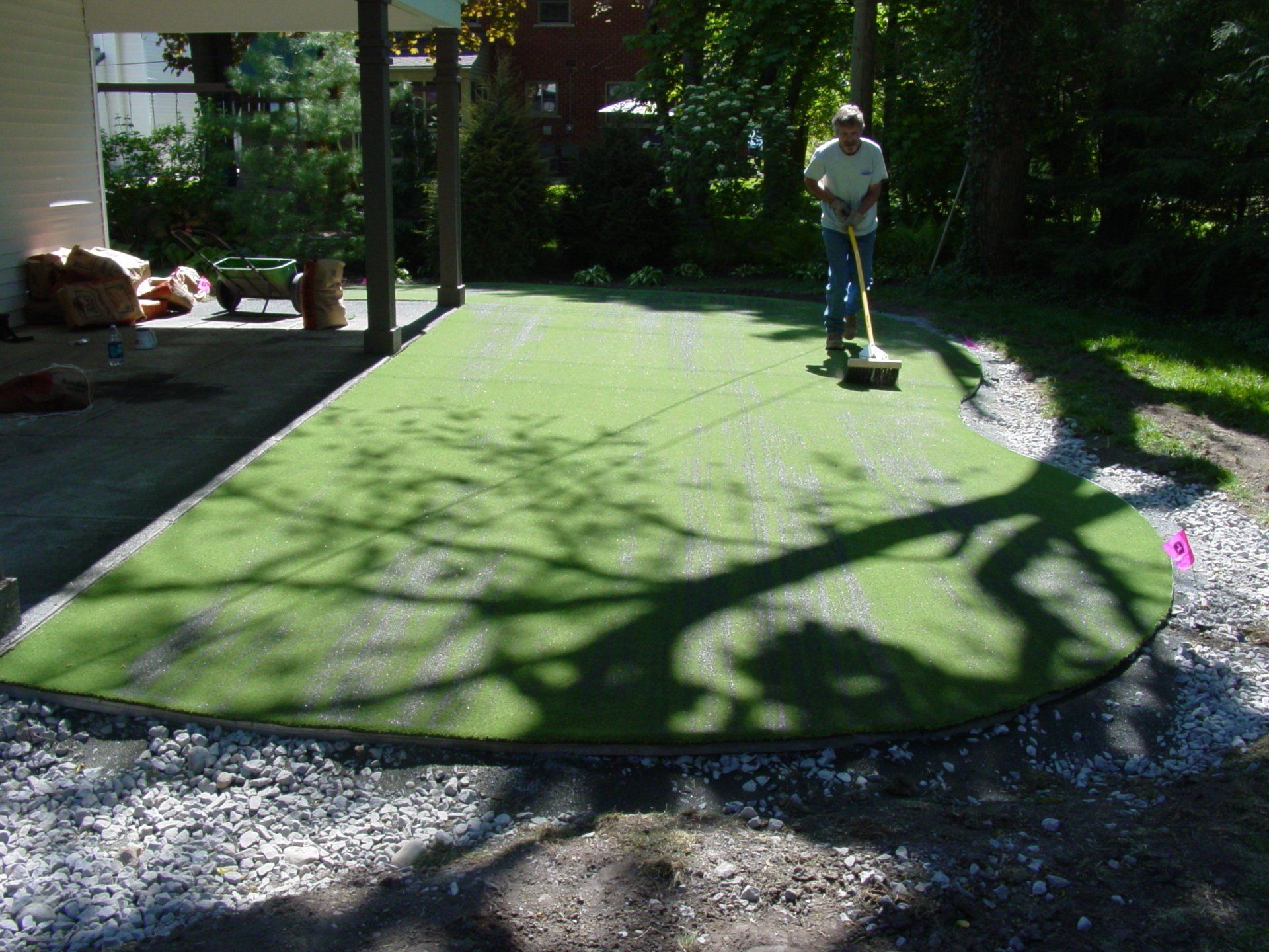 A man is sweeping a lawn with a broom