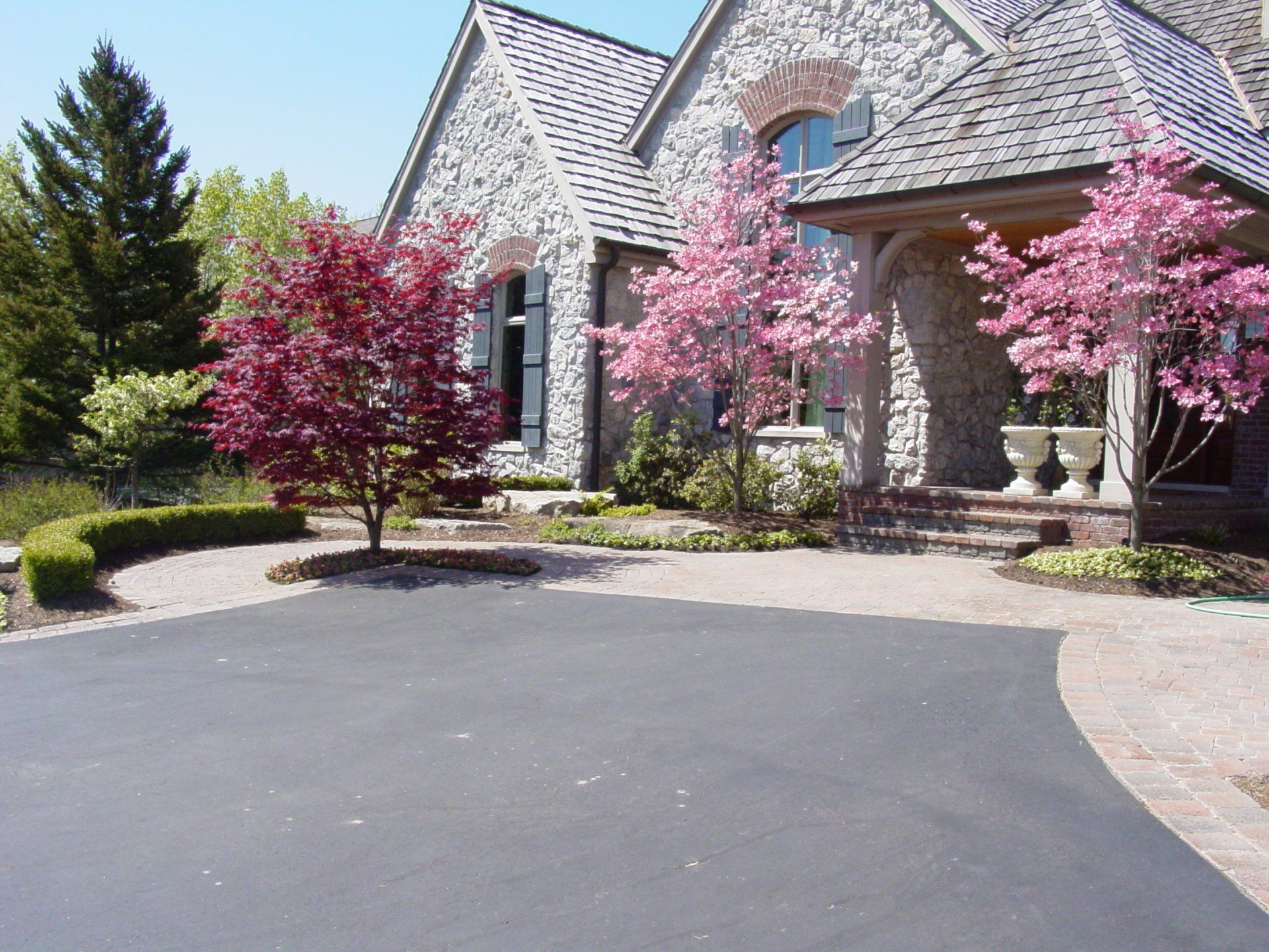A large house with pink flowers in front of it