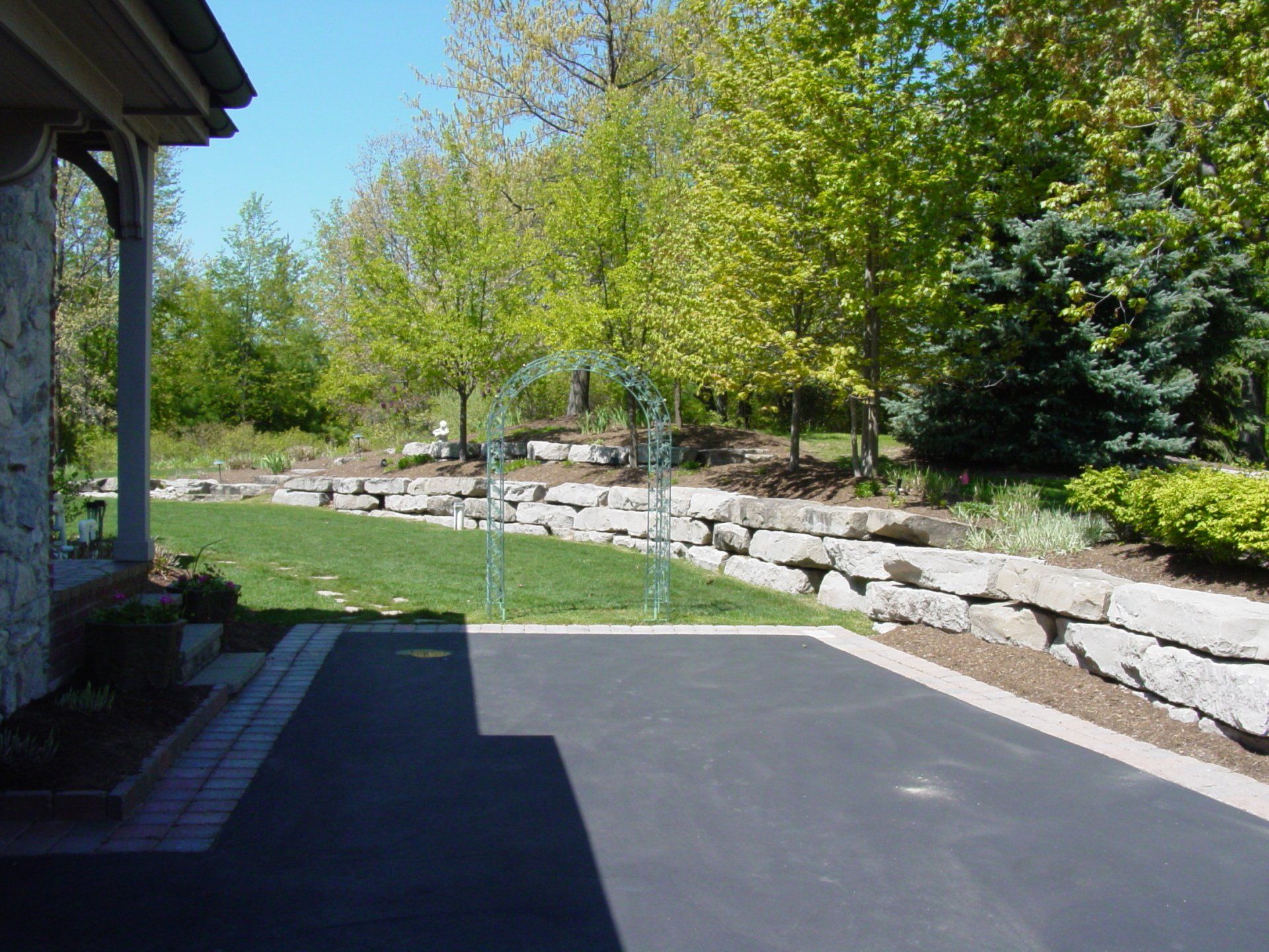A driveway leading to a house with trees in the background