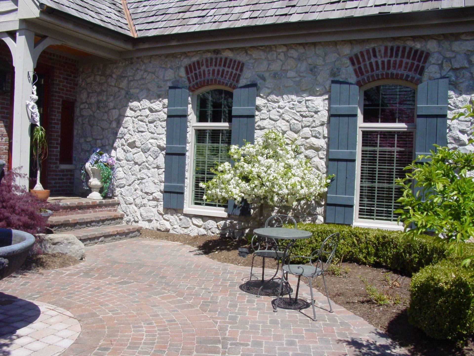 A stone house with blue shutters on the windows