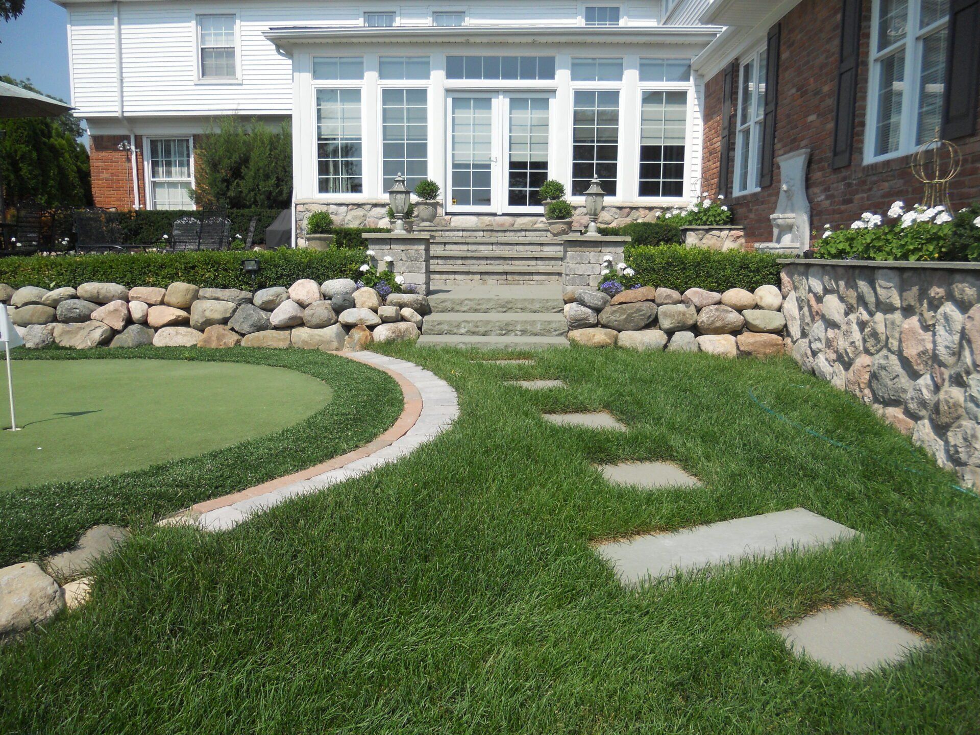 A large house with a green putting green in front of it