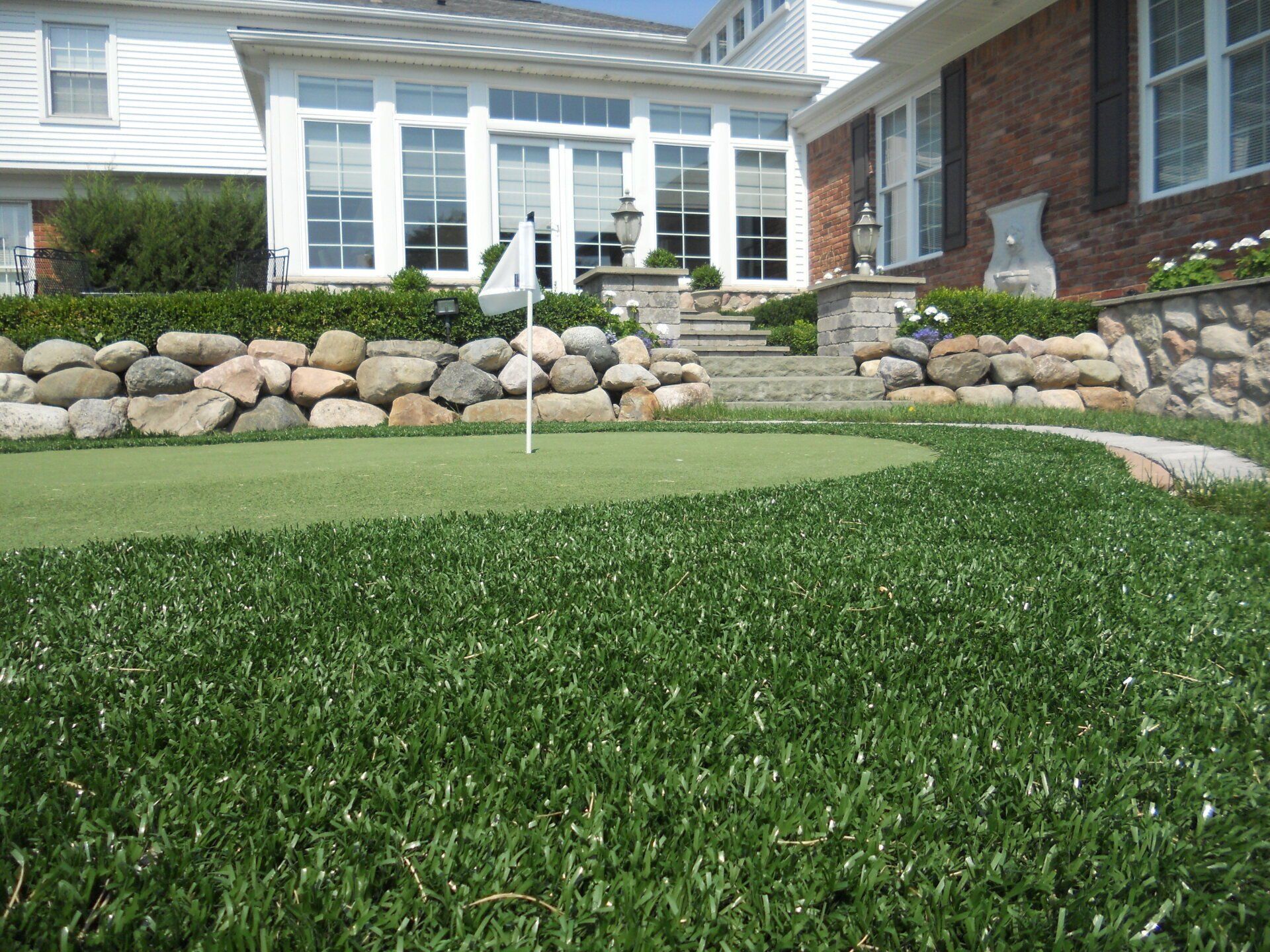 A house with a putting green in front of it