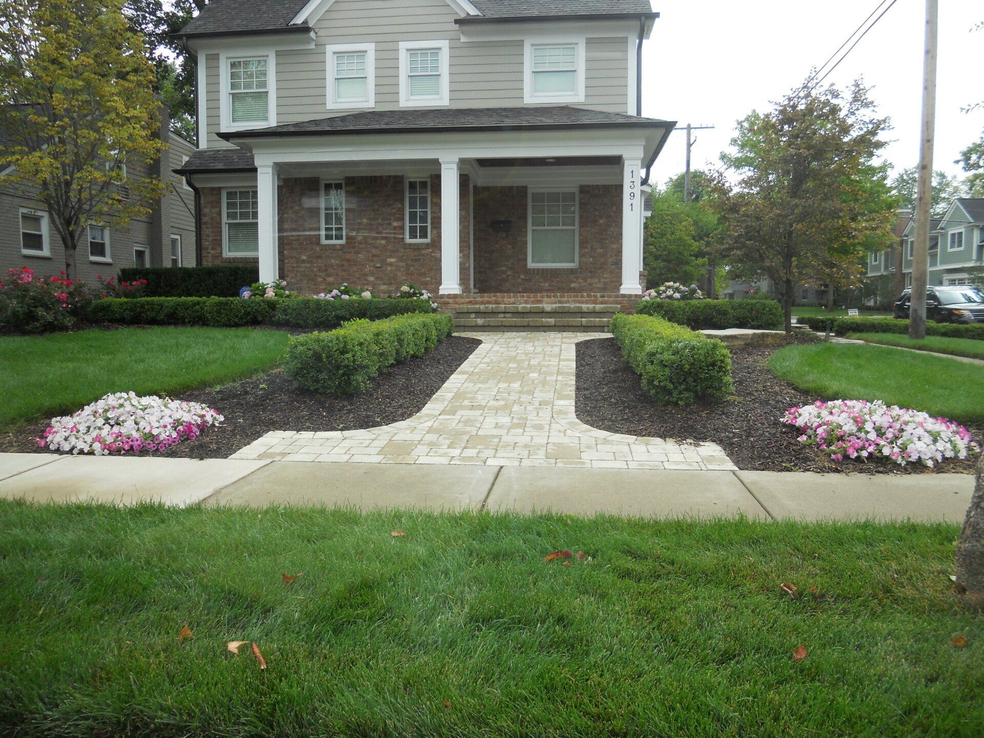A house with a walkway and flowers in front of it