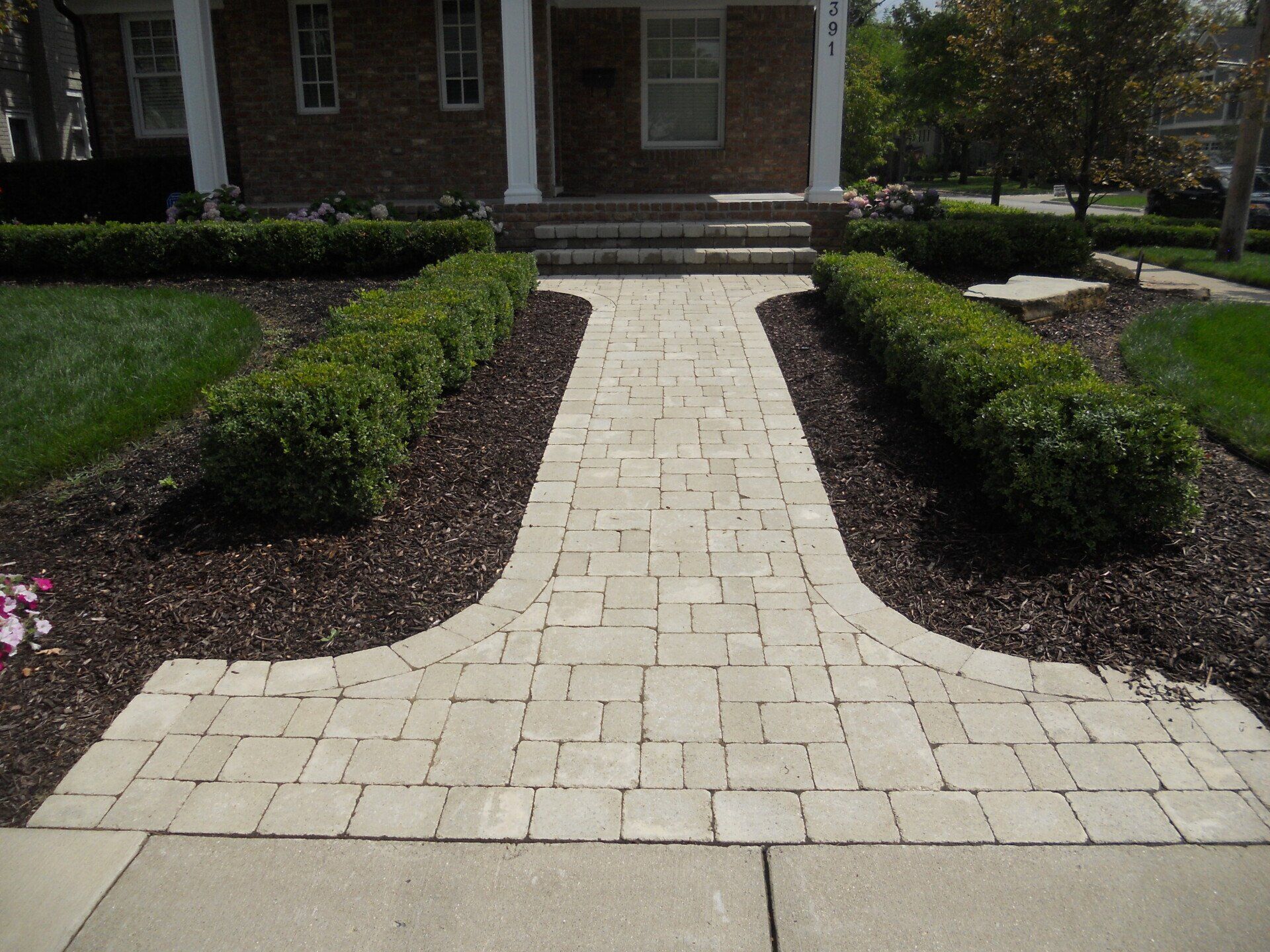 A brick walkway leading to a brick house