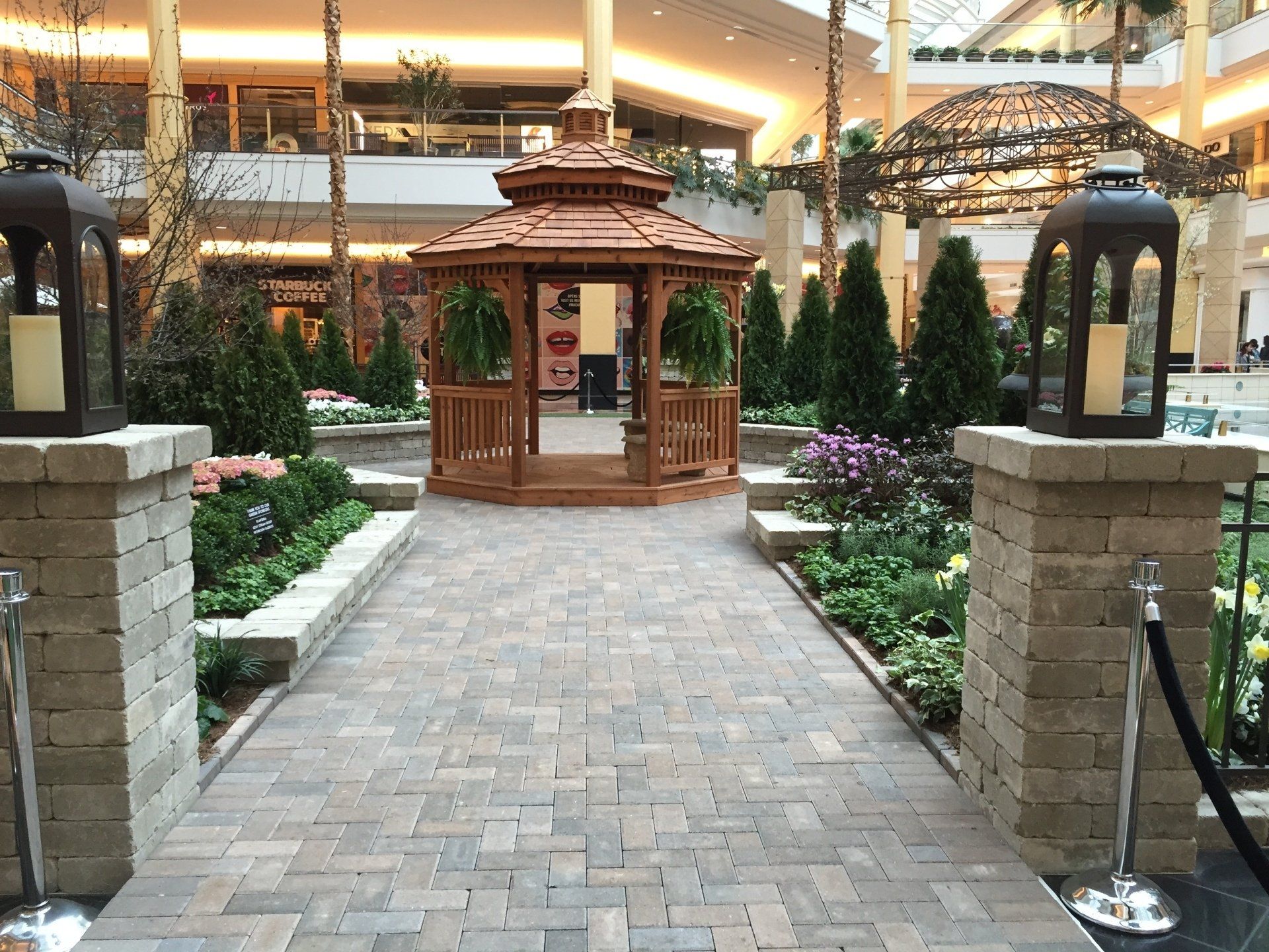 A gazebo in the middle of a mall surrounded by lanterns
